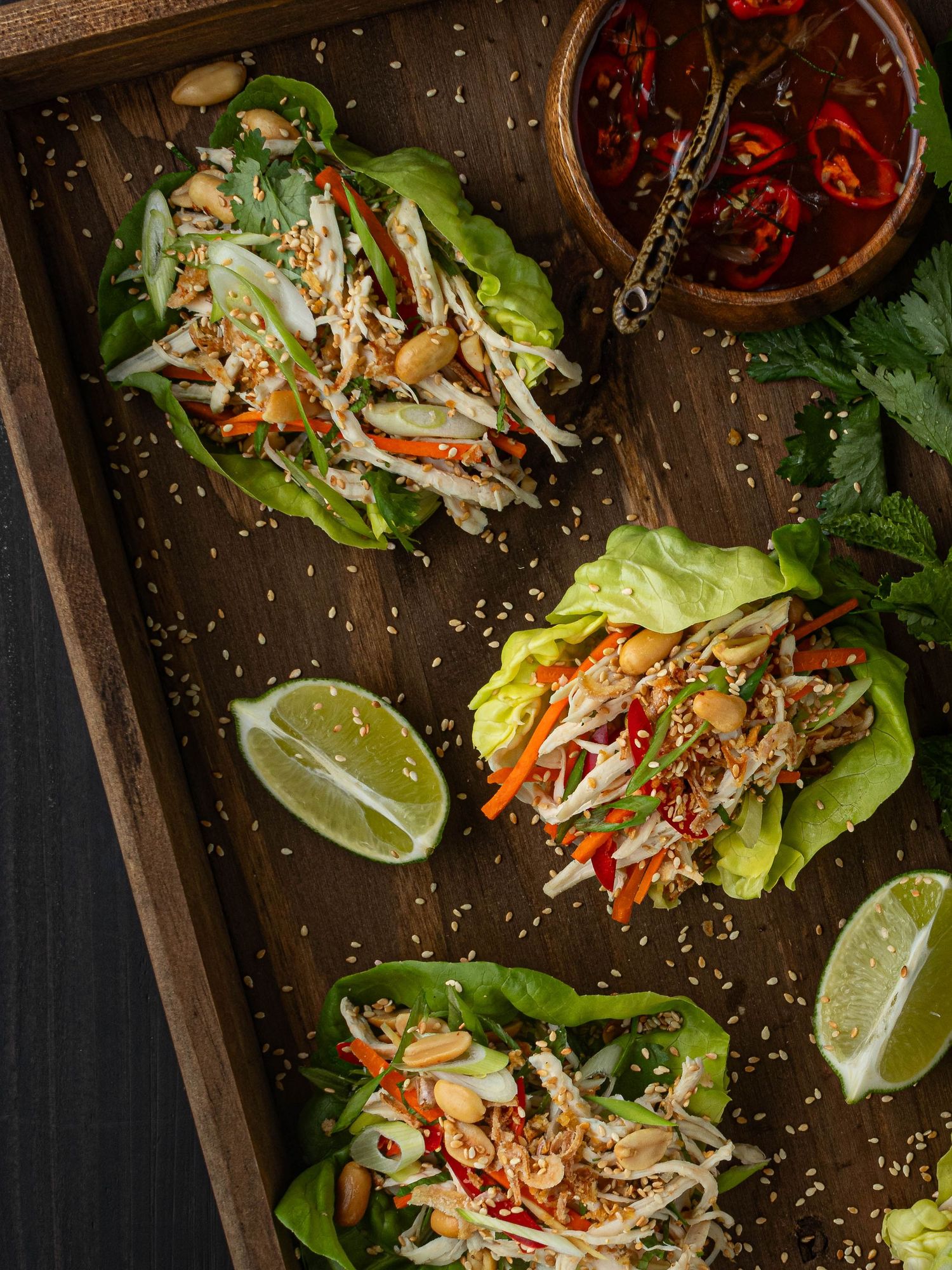 Flat lay photo of lettuce wraps with poached chicken and Thai herbs