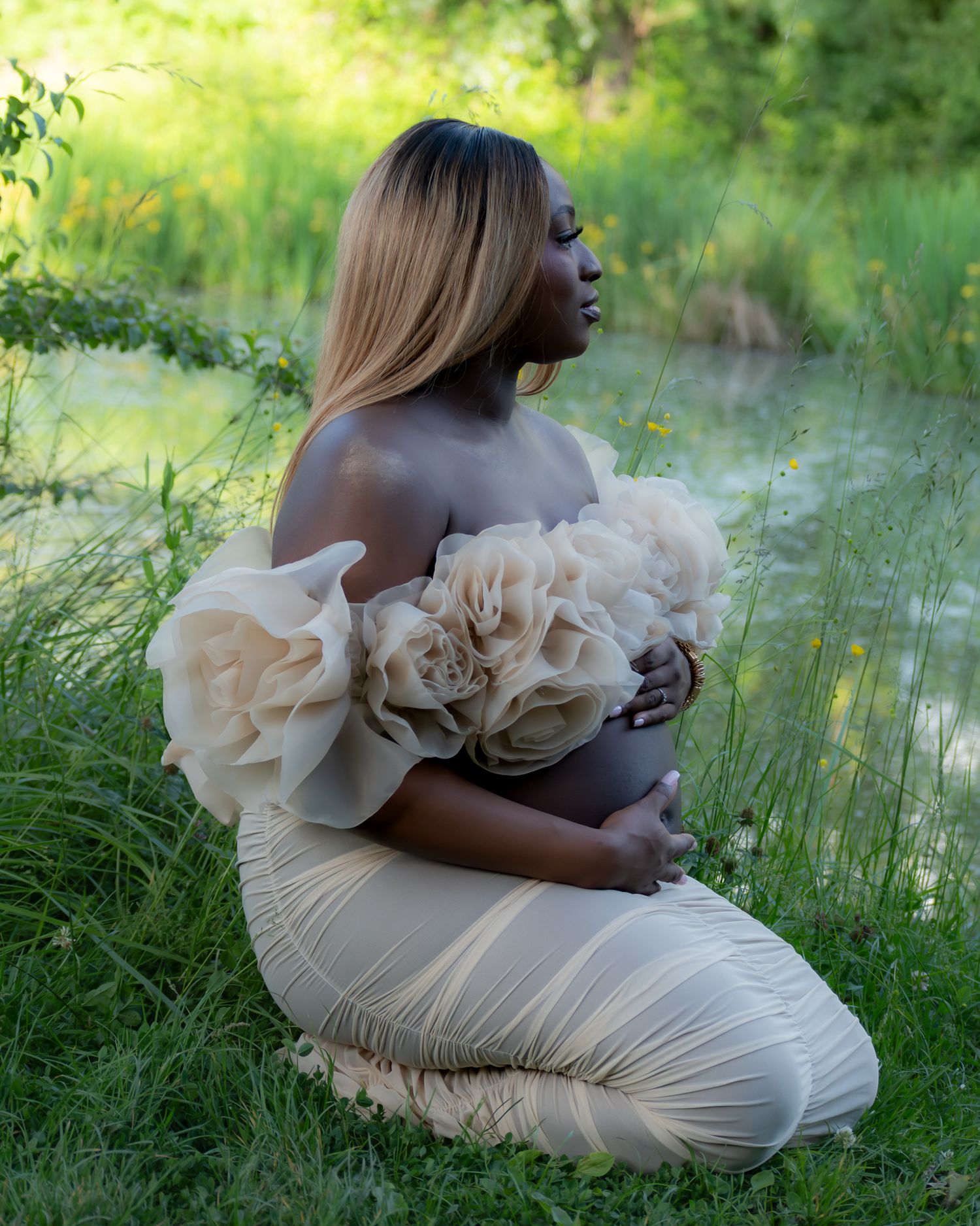 Photo artistique de grossesse en extérieur, bouquet de fleurs blanches, bord de rivière