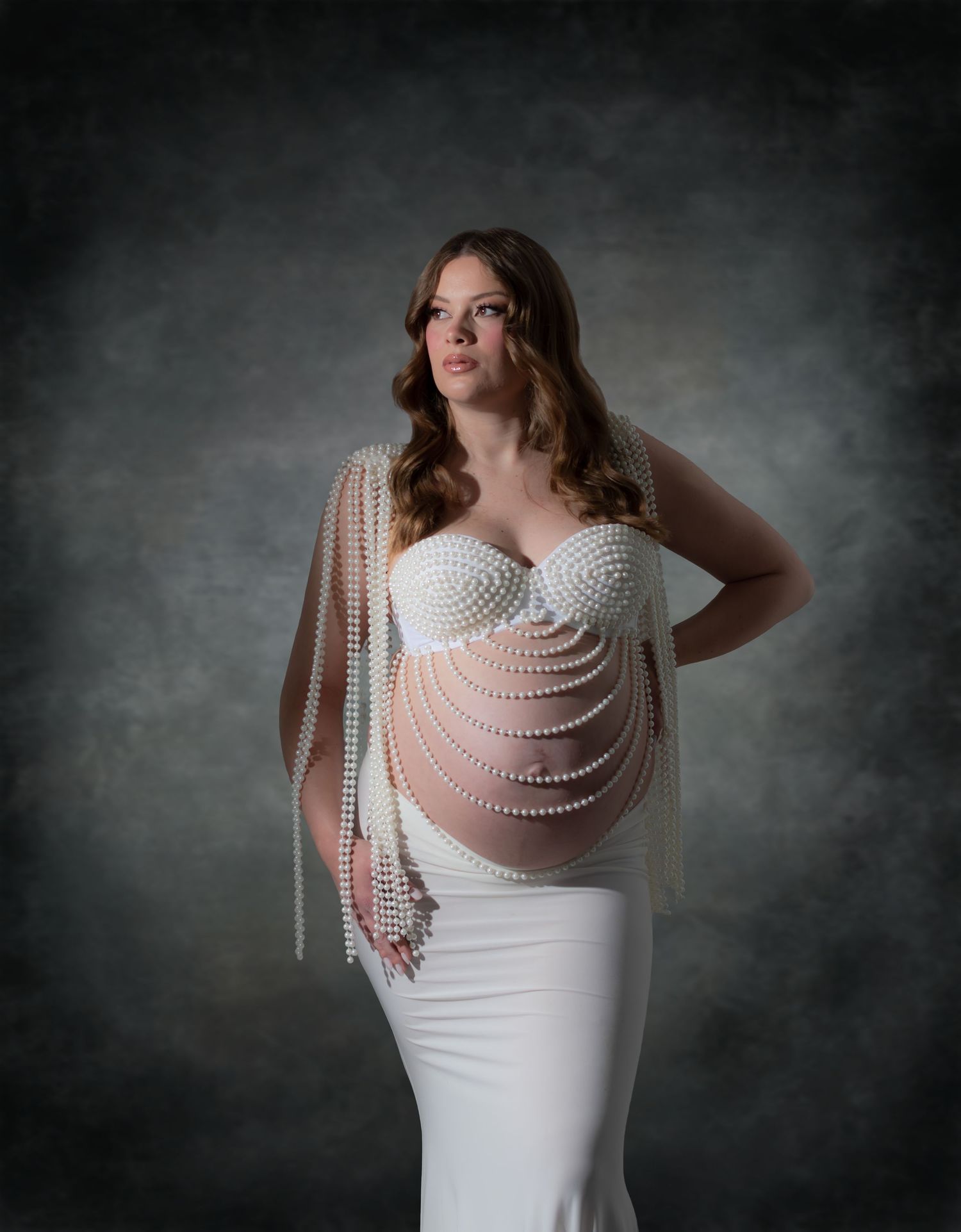 Portrait de grossesse en robe blanche fluide, fond sombre, studio