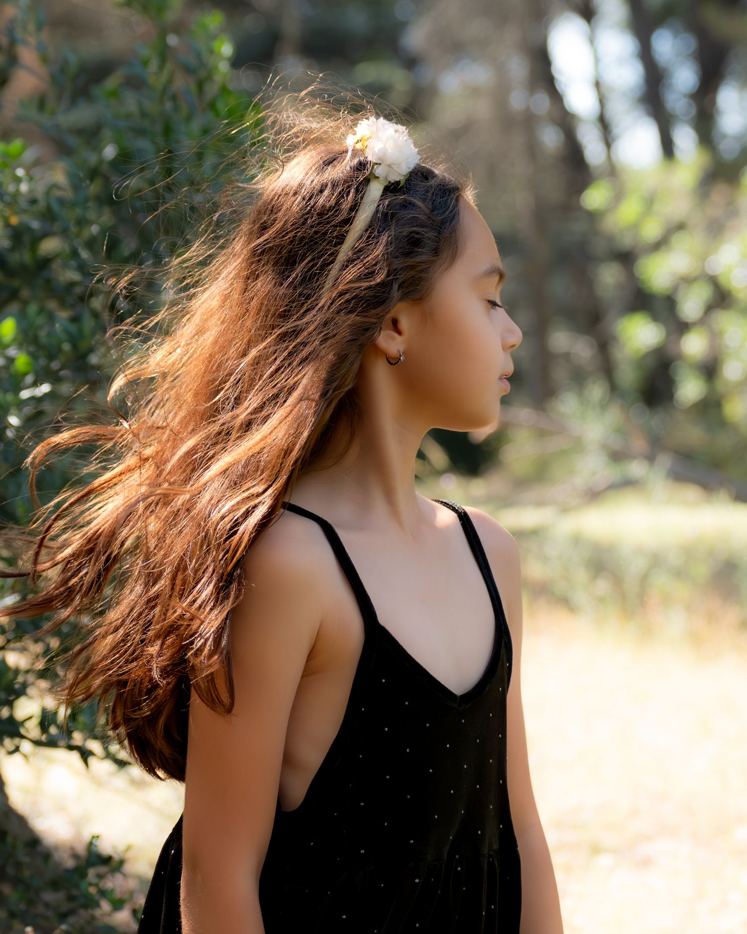 Portrait enfant en extérieur, cheveux au vent, lumière naturelle