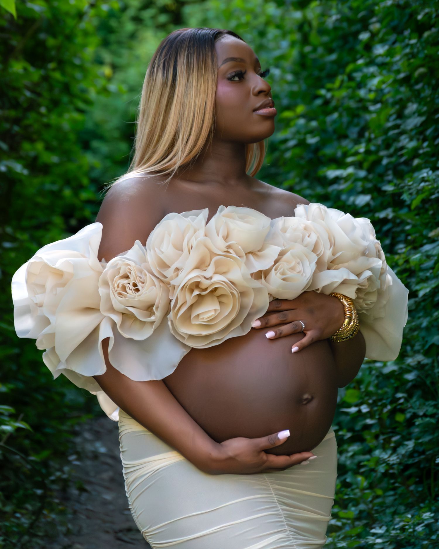 Portrait de grossesse en extérieur, robe fleurie blanche, lumière naturelle