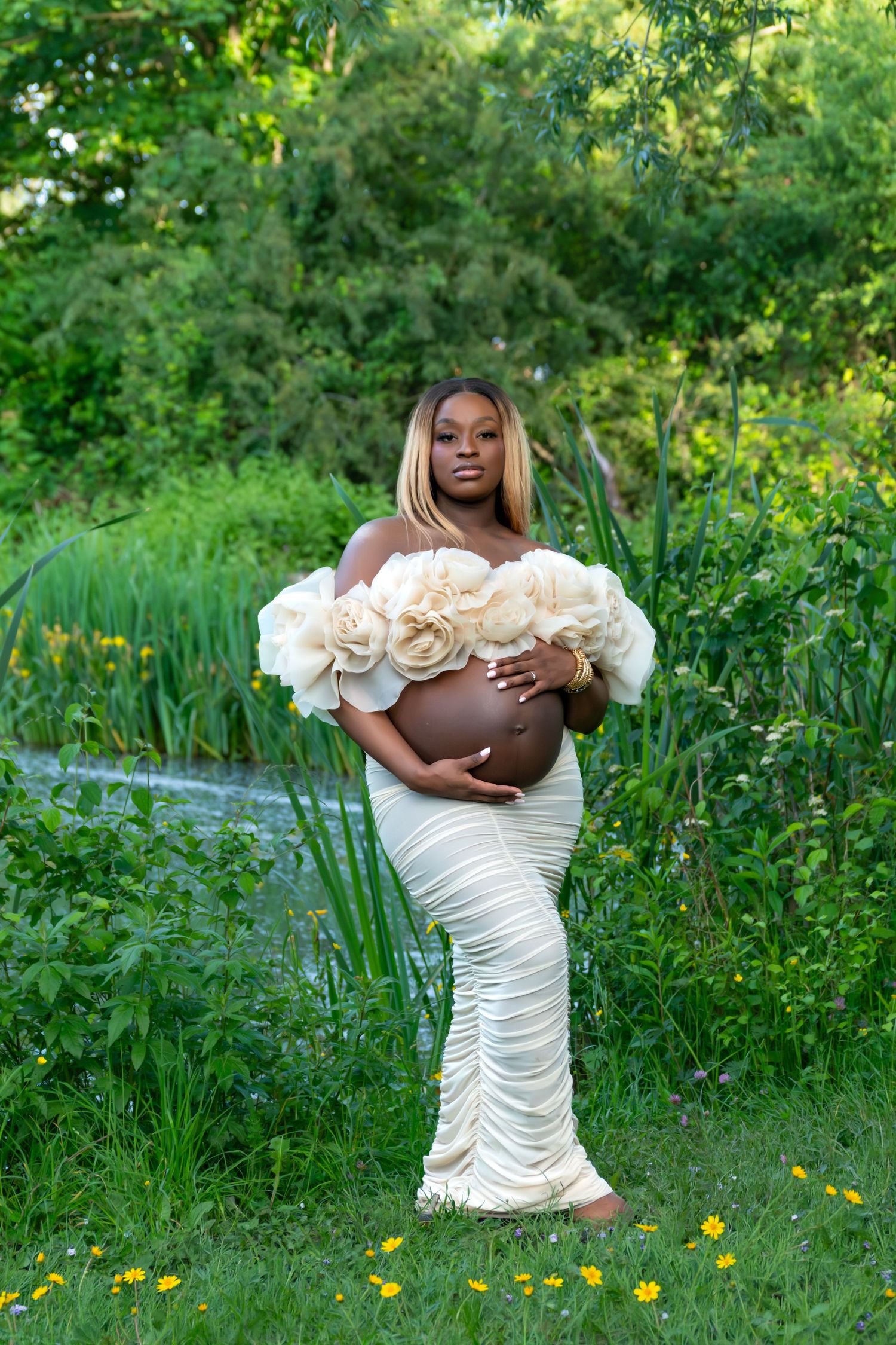 Photo de grossesse en extérieur, robe fleurie blanche, ambiance champêtre