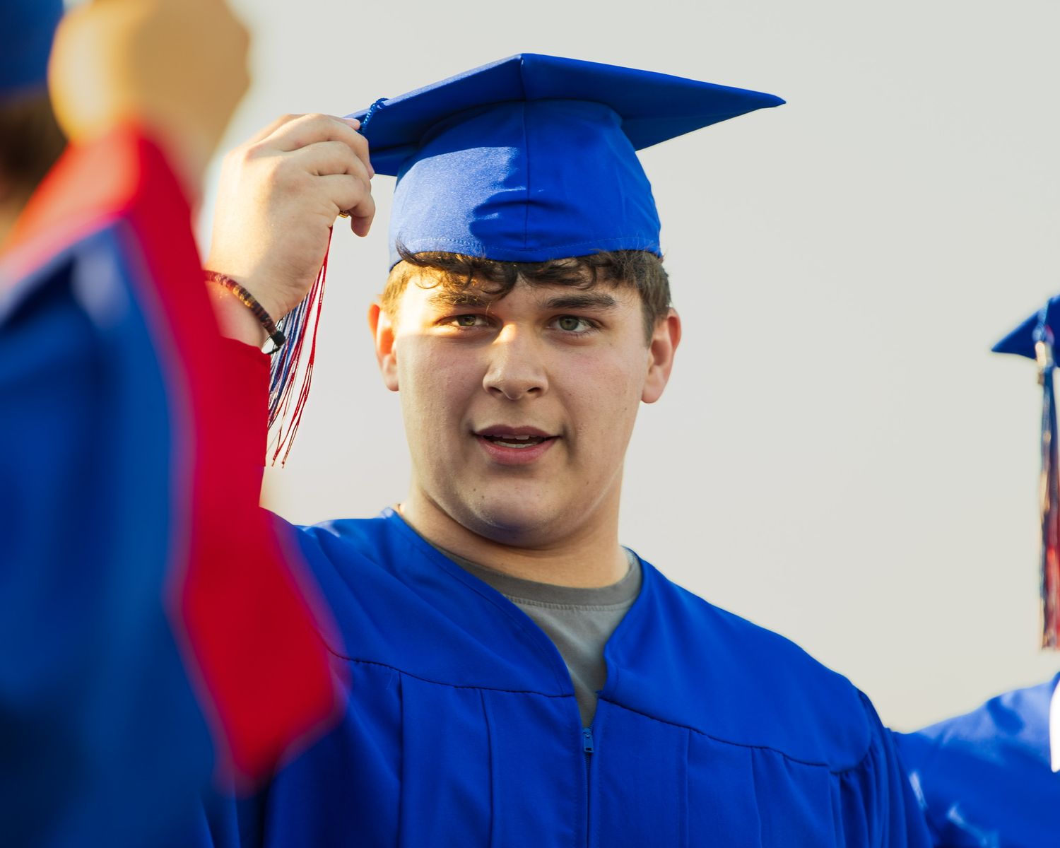 student in cap and gown moving their tassle