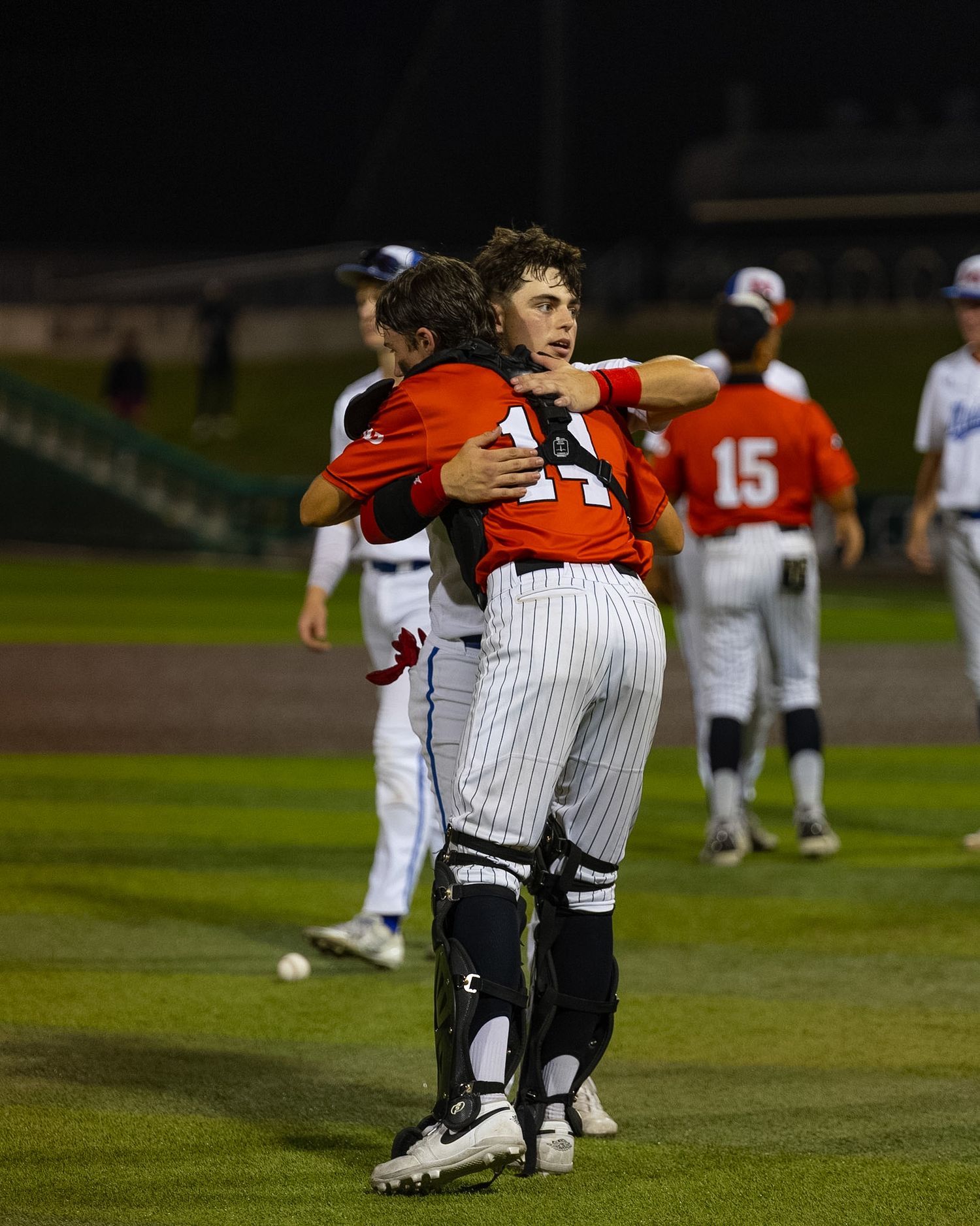 two baseball players hugging after a game