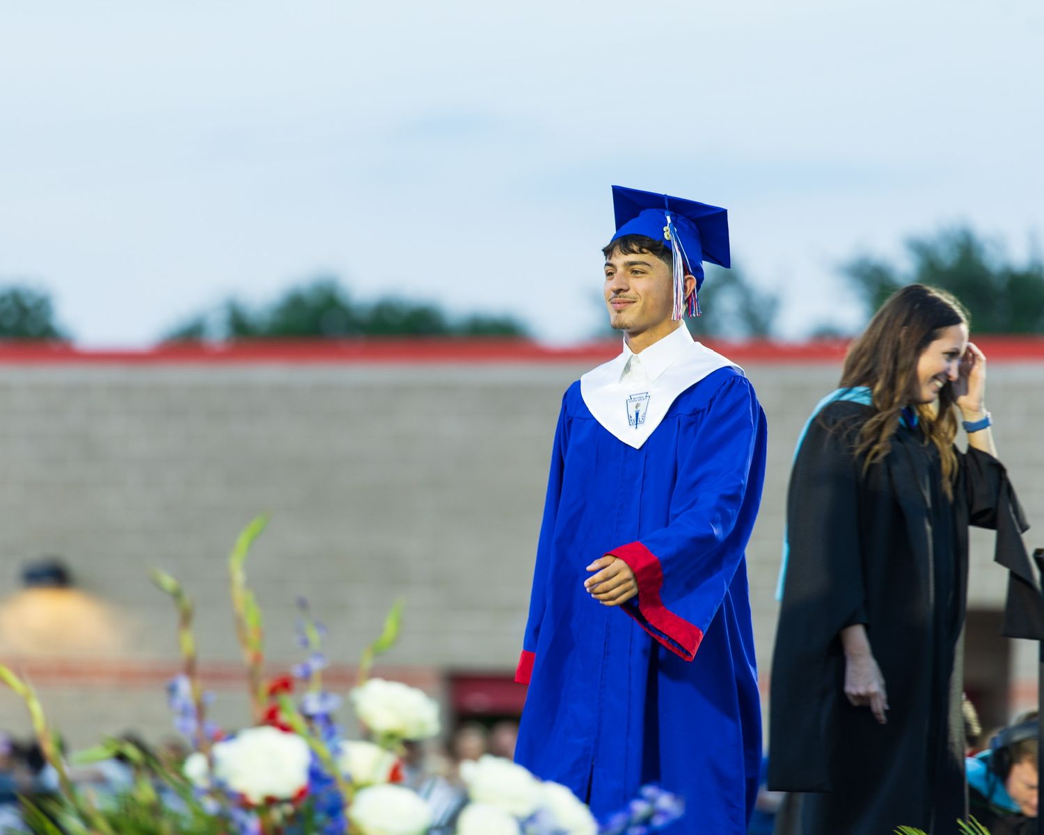 student in cap and gown walking across the stage