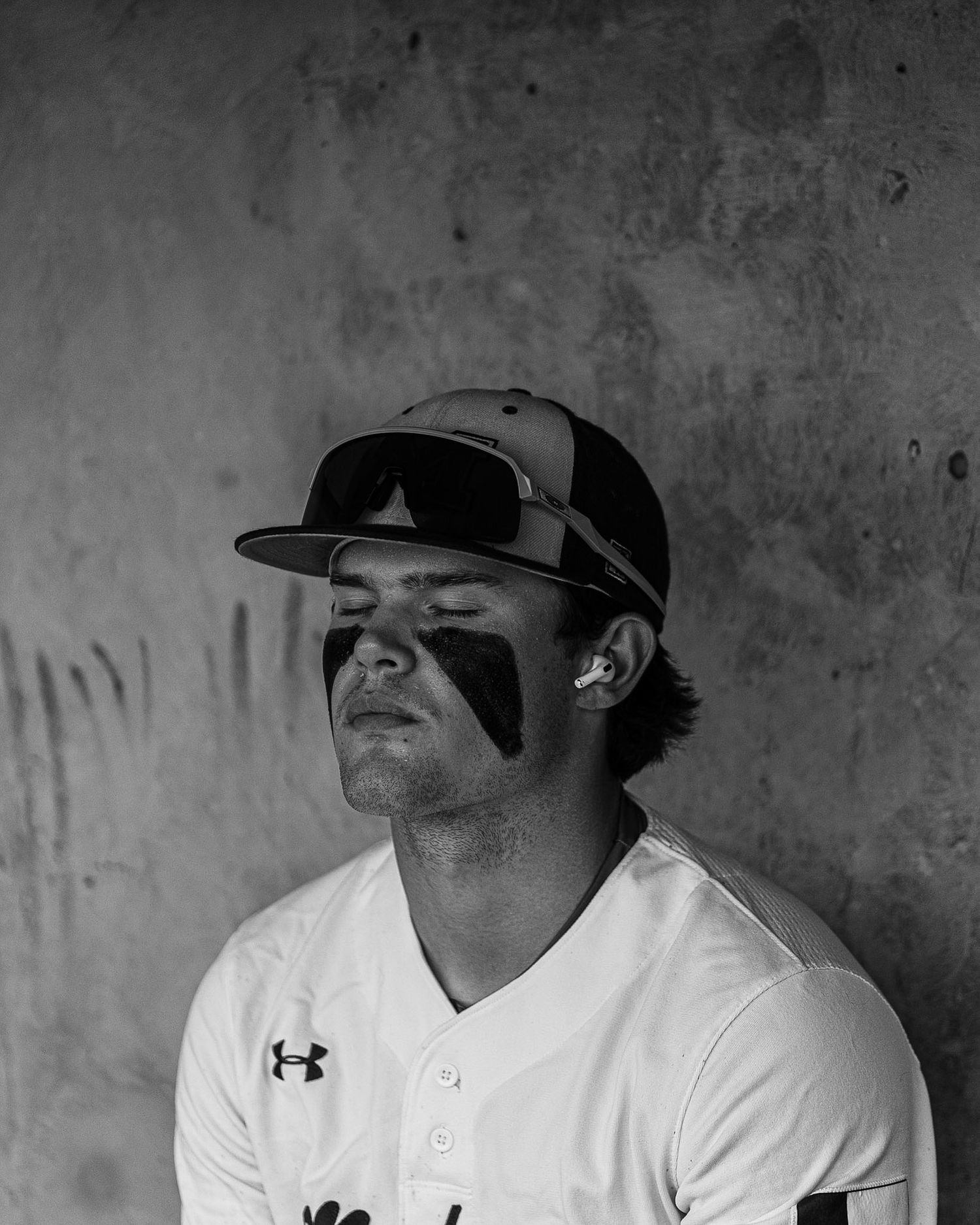 baseball player sitting in the dugout with eyes closed