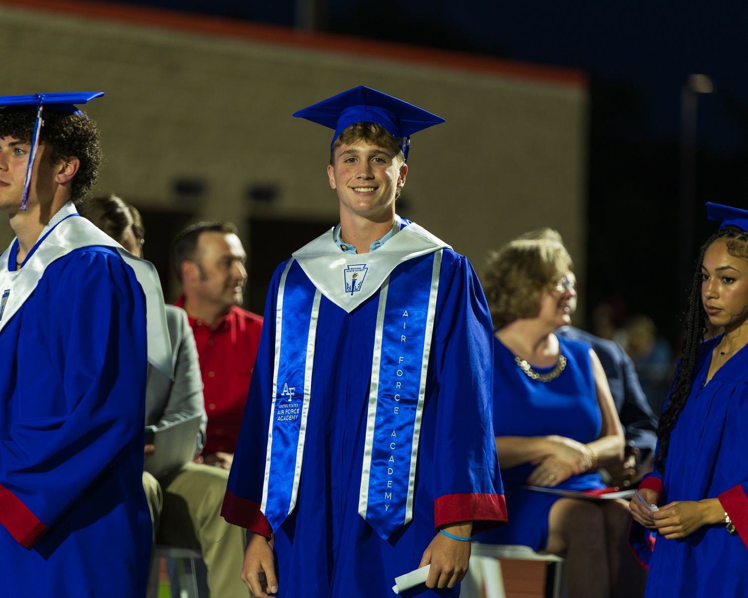 student in cap and gown waiting in line to walk the stage