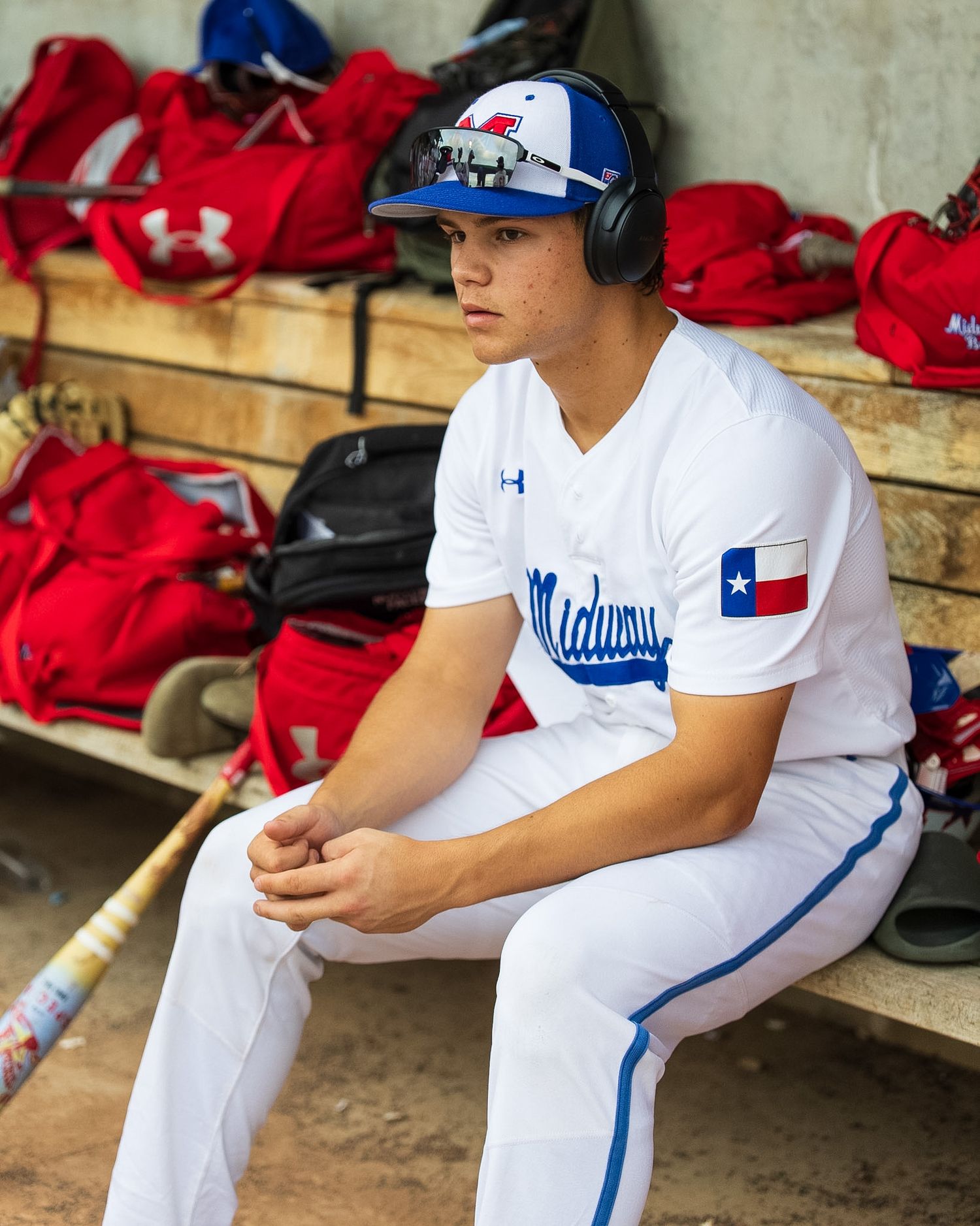 baseball player sitting on the bench with headphones
