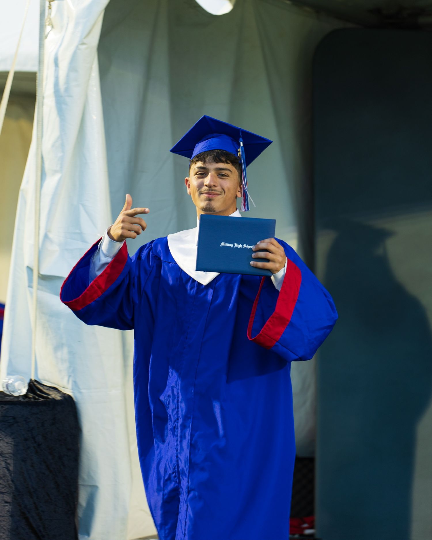student in cap and gown receiving their diploma