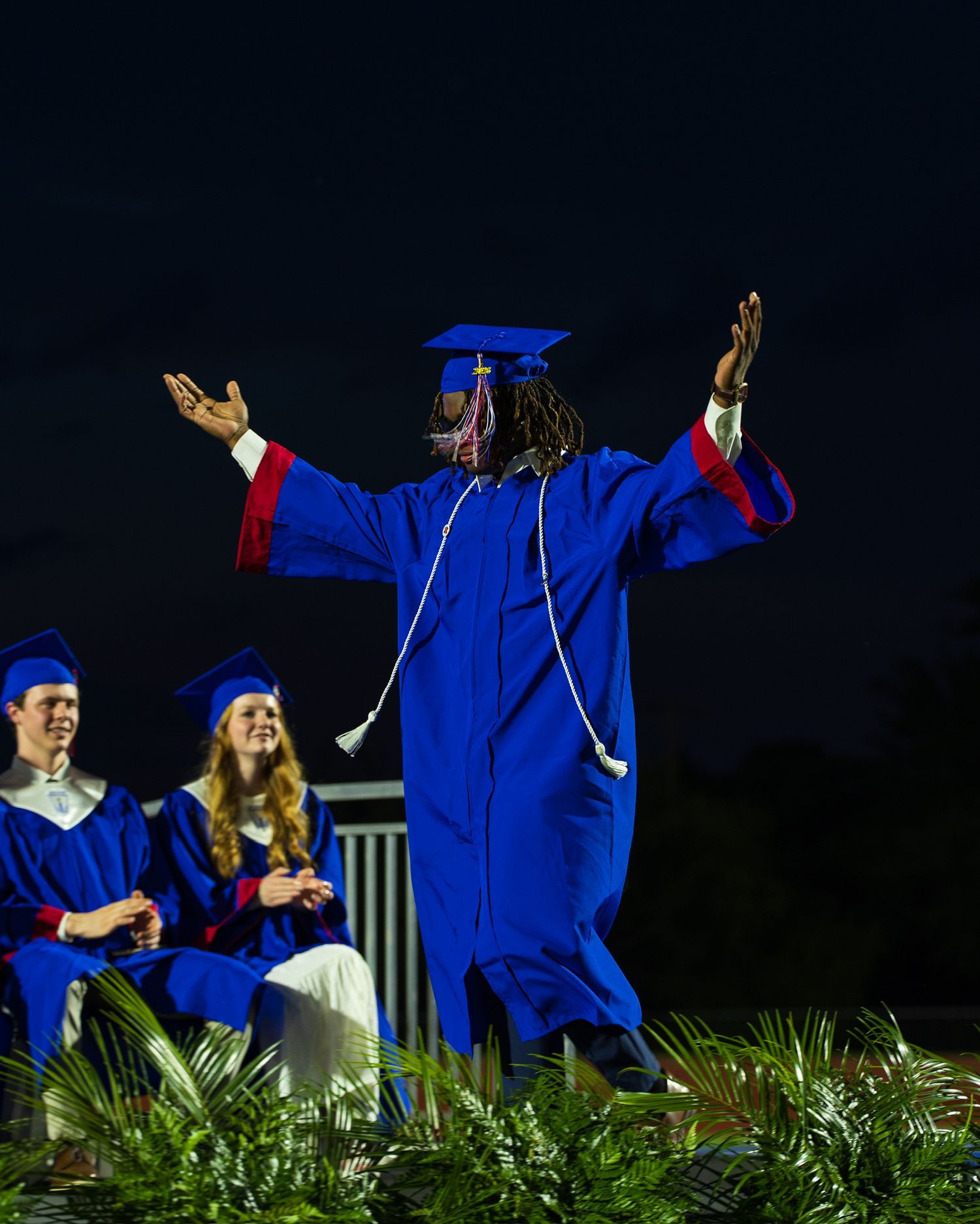 student in cap and gown walking across the stage in celebration