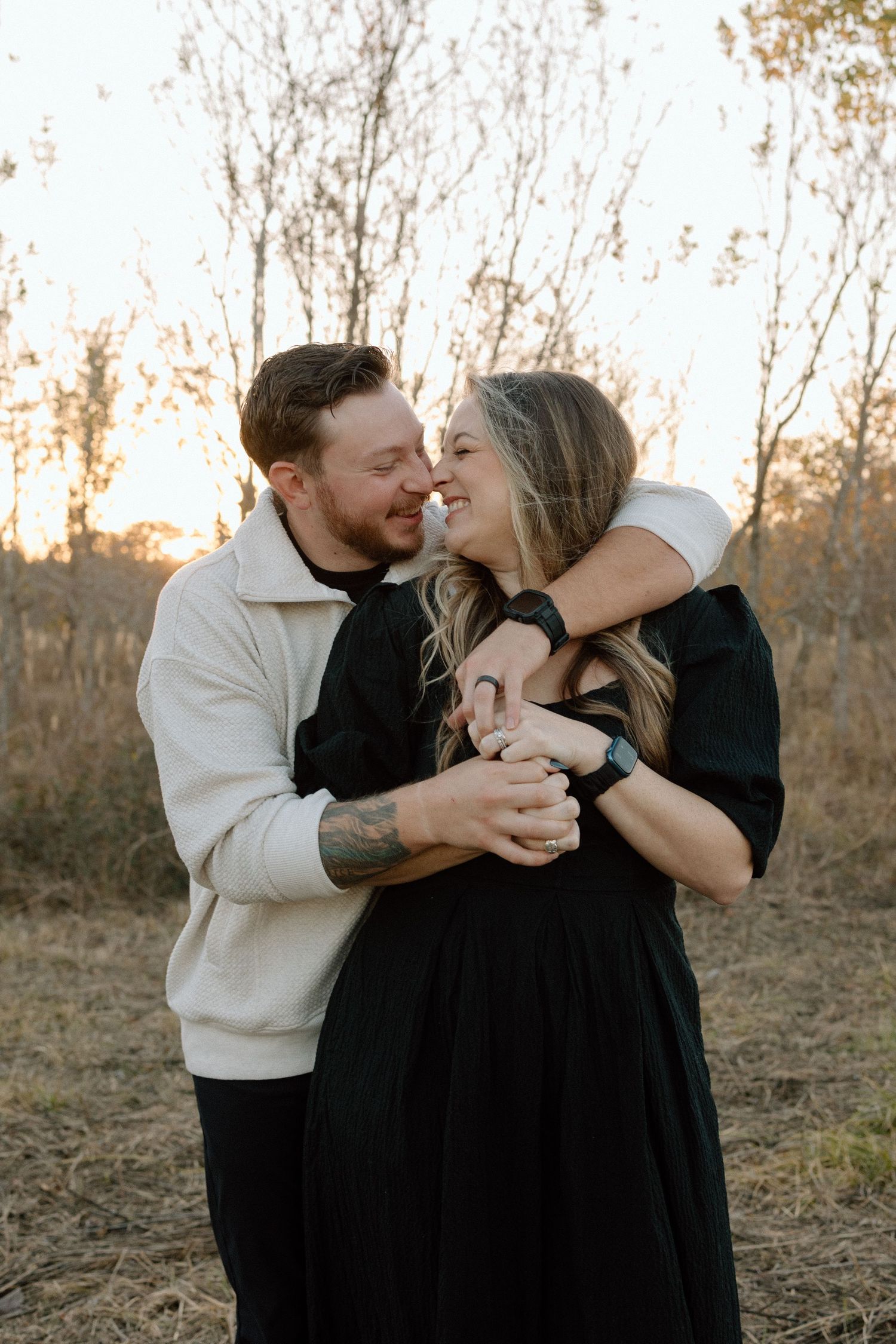 Couple dances and smiles together during a romantic fall sunset engagement session.