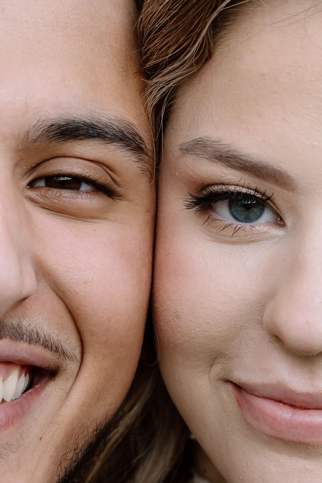 Intimate close-up portrait of smiling couple with foreheads touching showing their eyes.