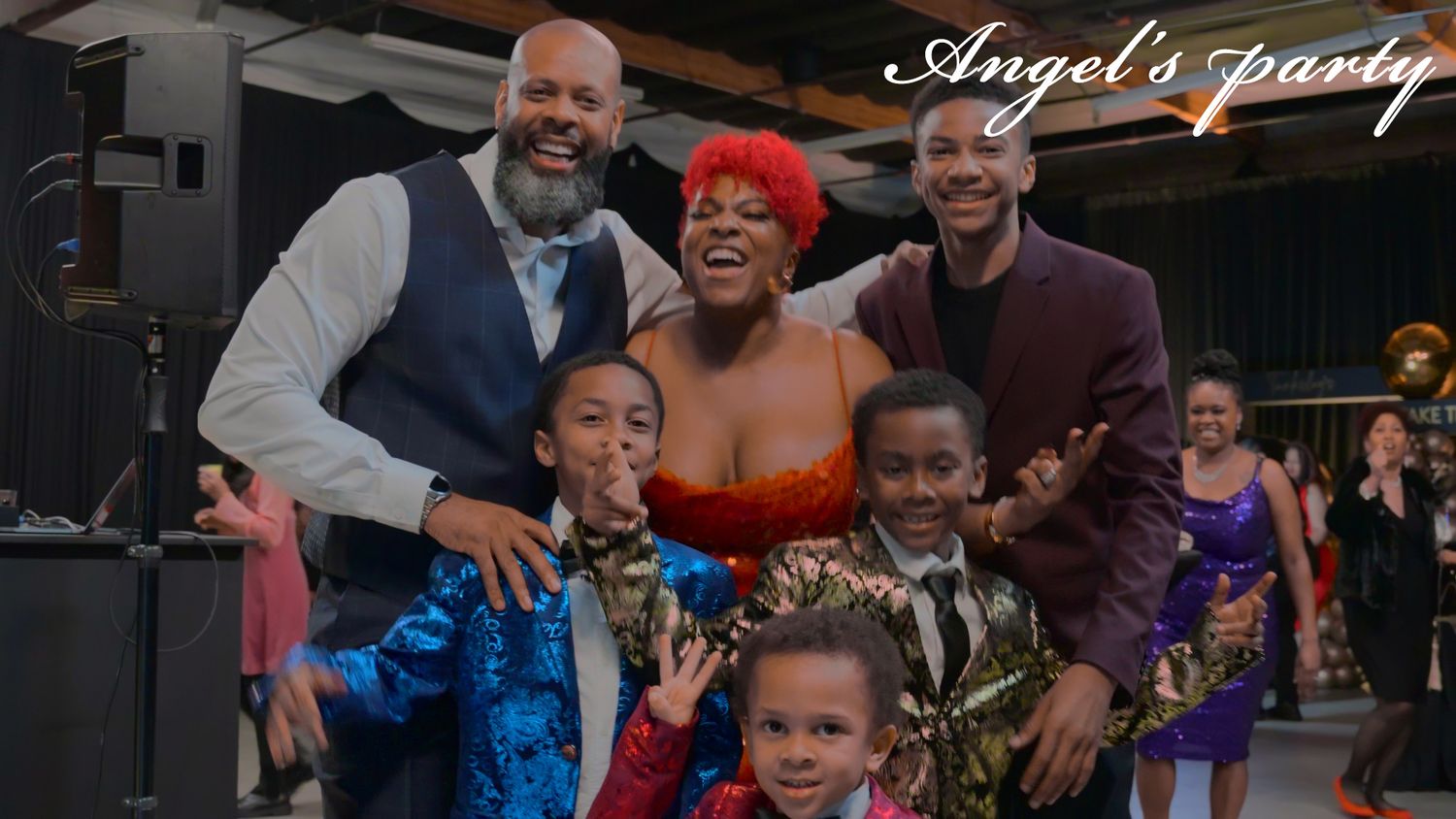 A joyful family gathering at a formal celebration with decorative lighting.