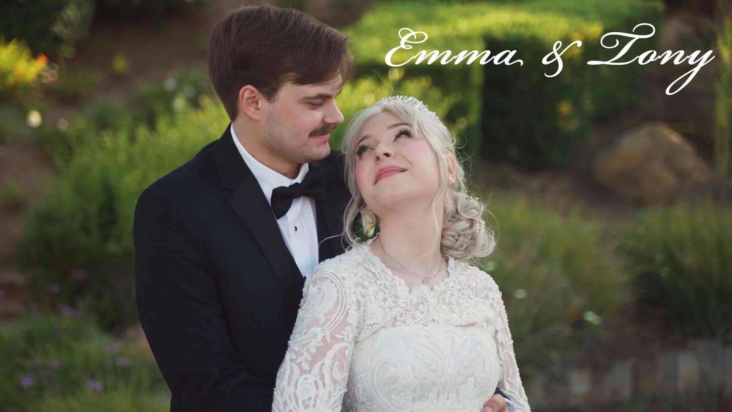 Romantic wedding portrait in garden setting with elegant formal attire.