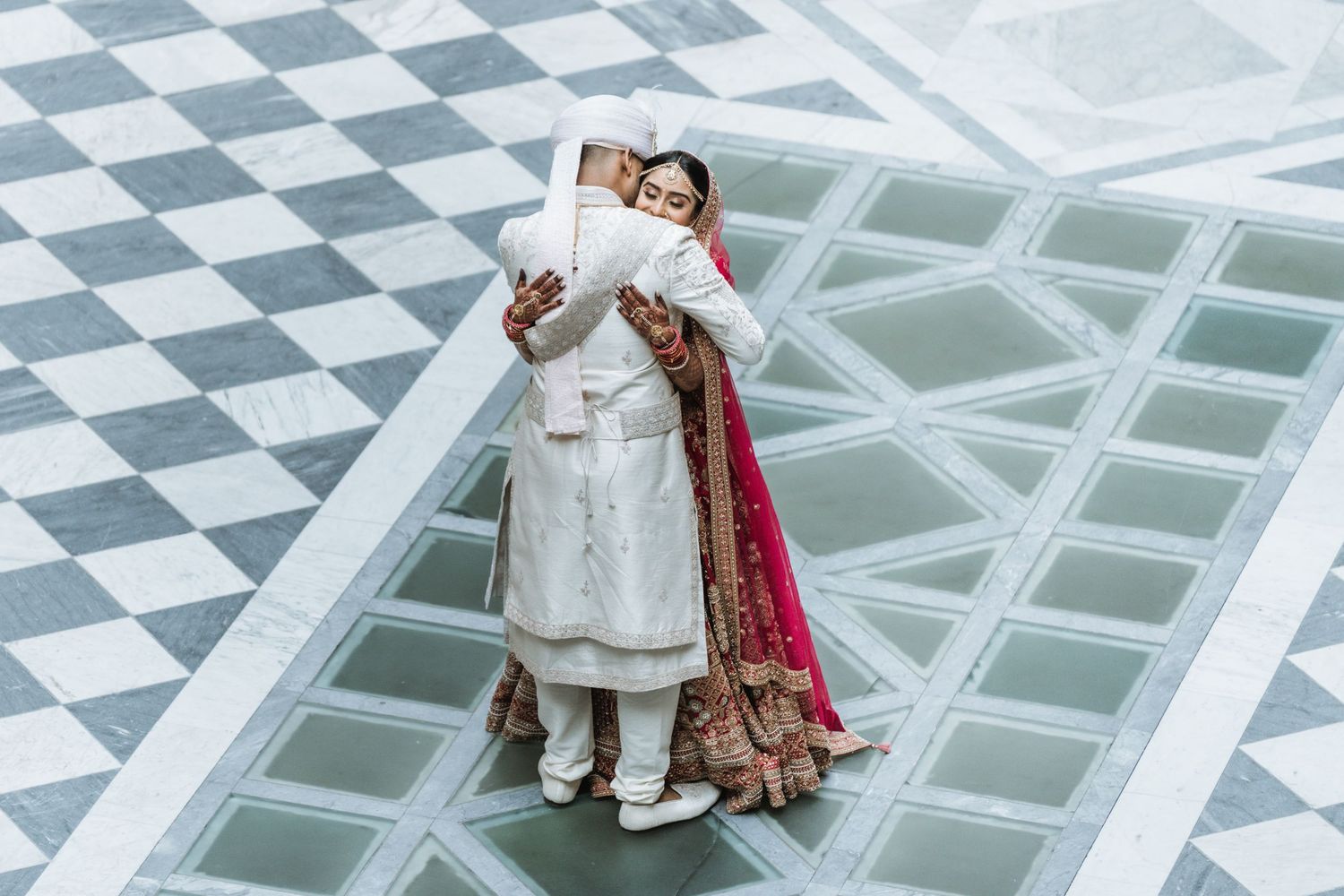Memory Lane Studios luxury Indian wedding photography featuring couple in traditional attire on elegant geometric floor by Tharun Palla