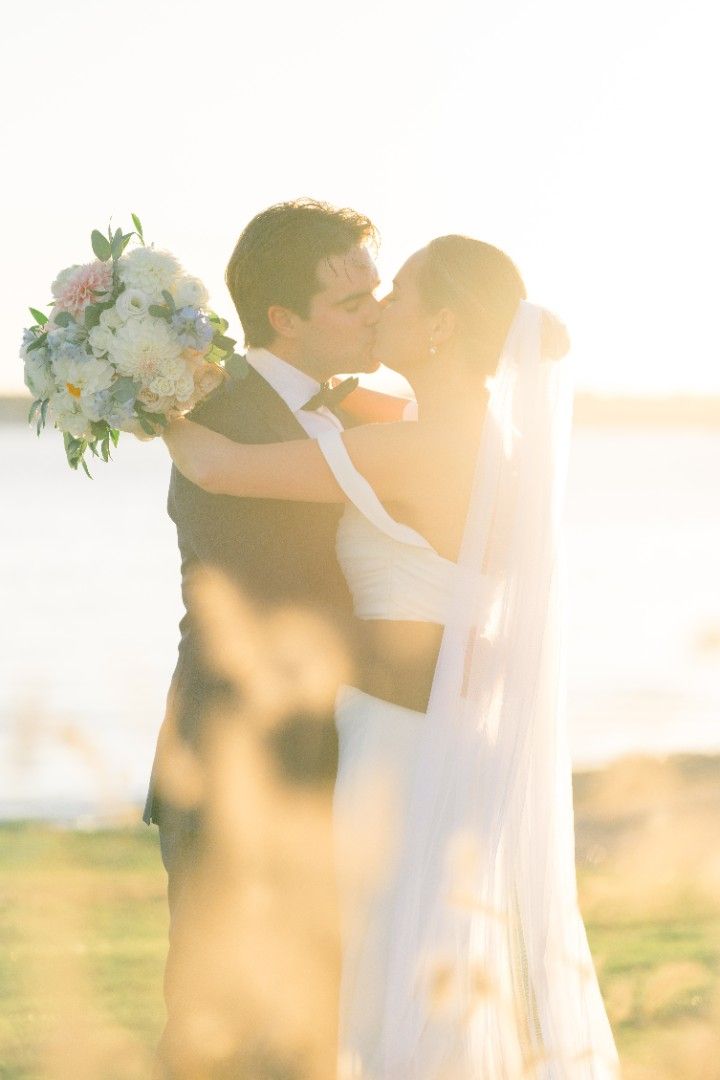 Memory Lane Studios golden hour wedding photography in Connecticut featuring romantic couple embrace with floral decorations at sunset