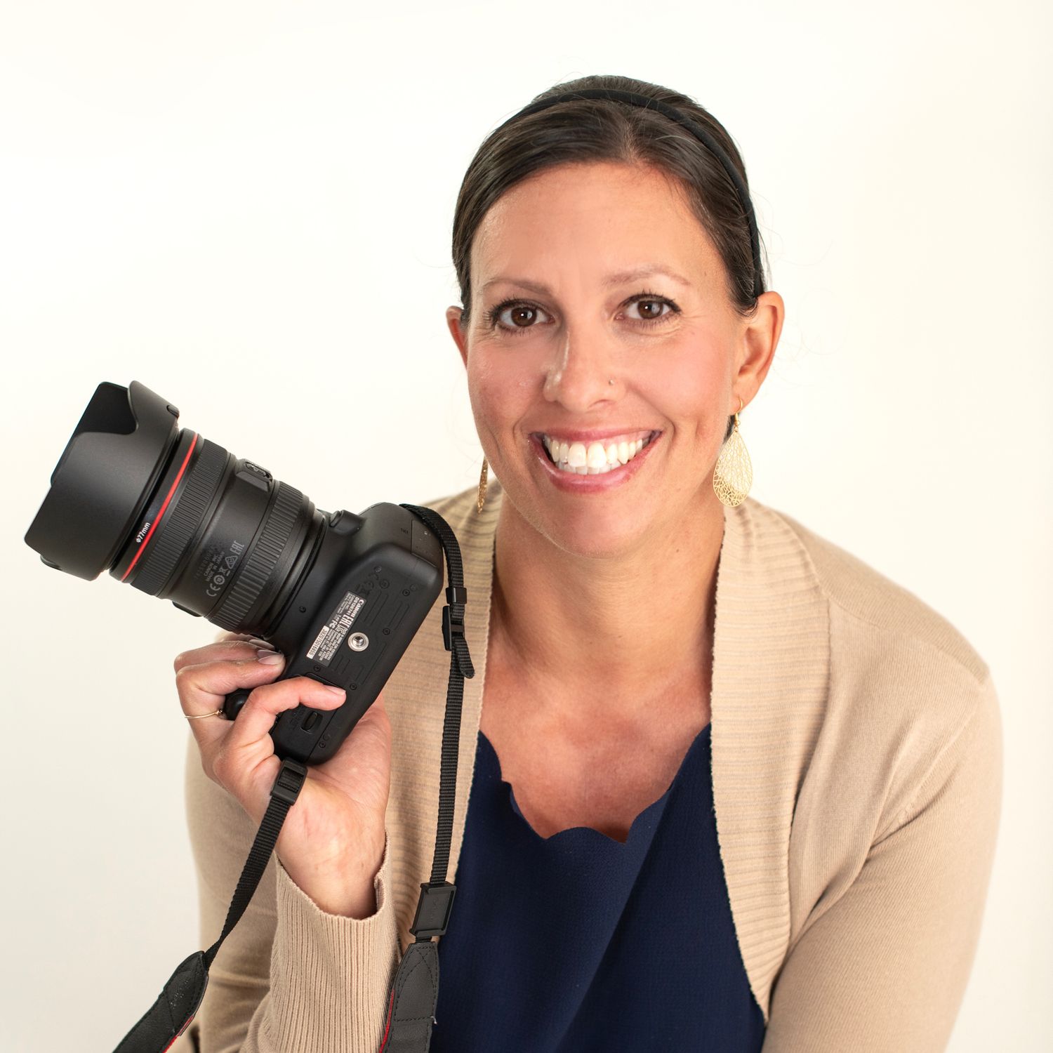 Professional photographer in beige sweater holding camera and smiling in three different poses against white background.