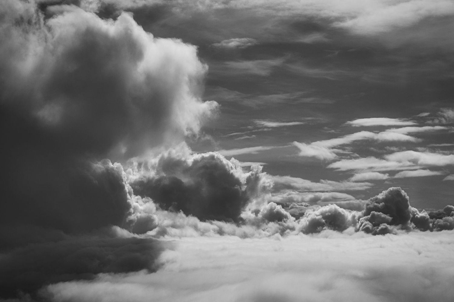 Dramatic black and white panoramic landscape with dark storm clouds rolling across a moody sky.