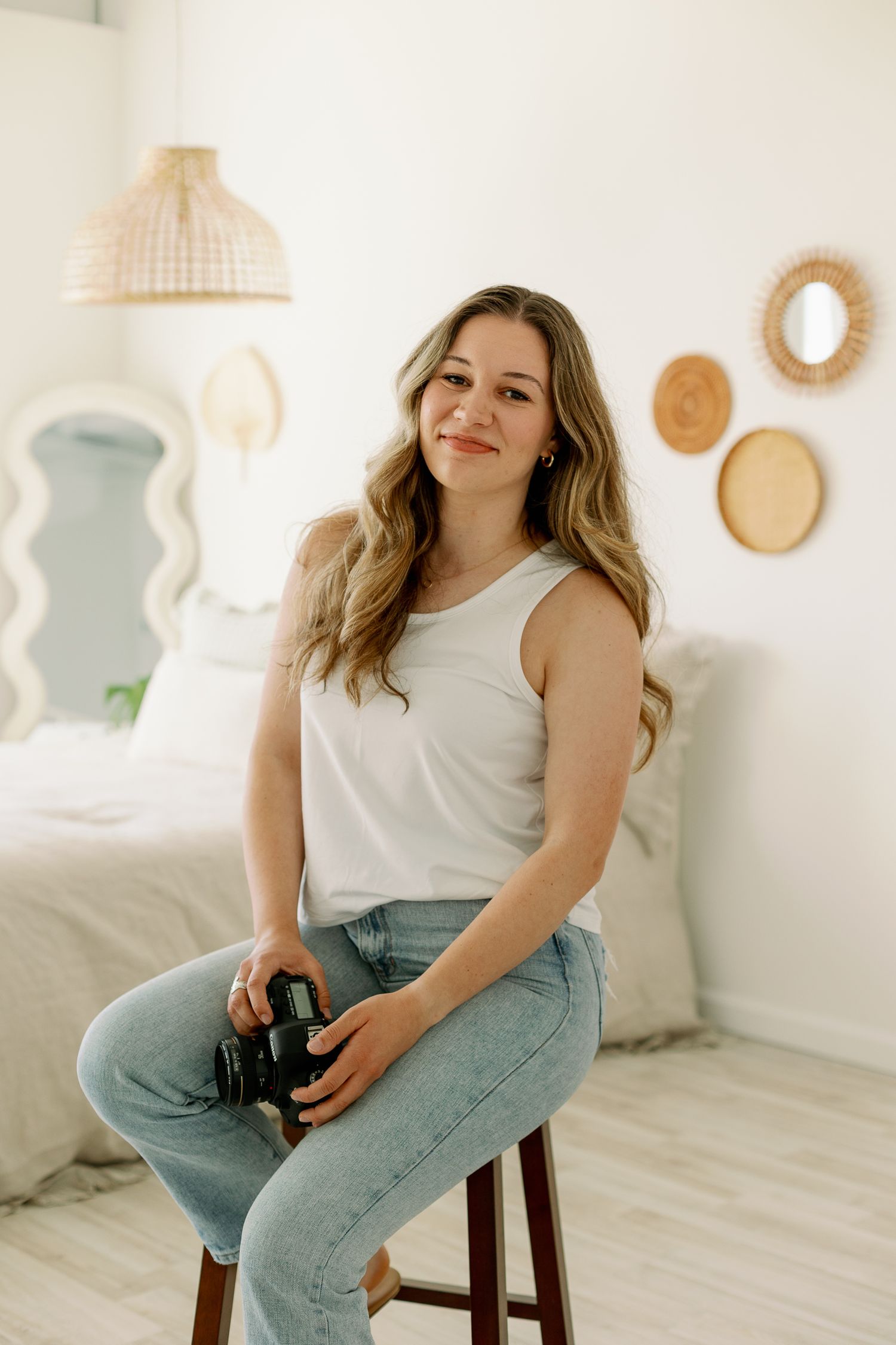Casual portrait session in bright white room with woven wall decor.