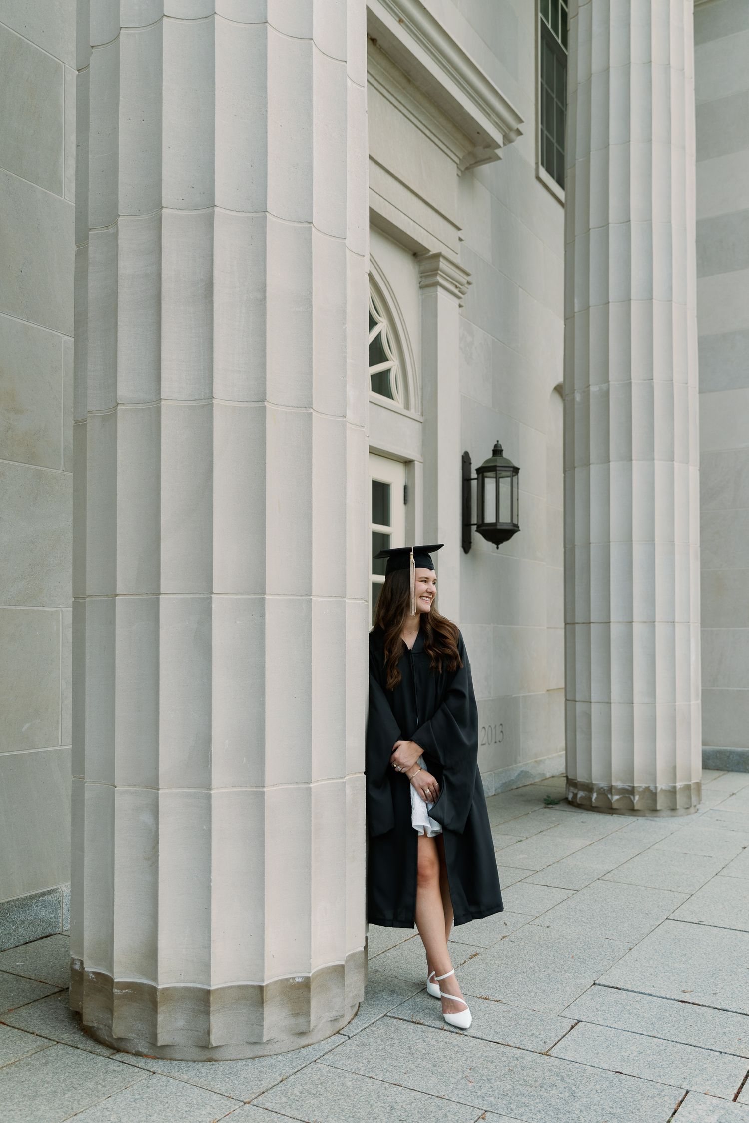 Artistic engagement photos taken between white classical columns of historic building.