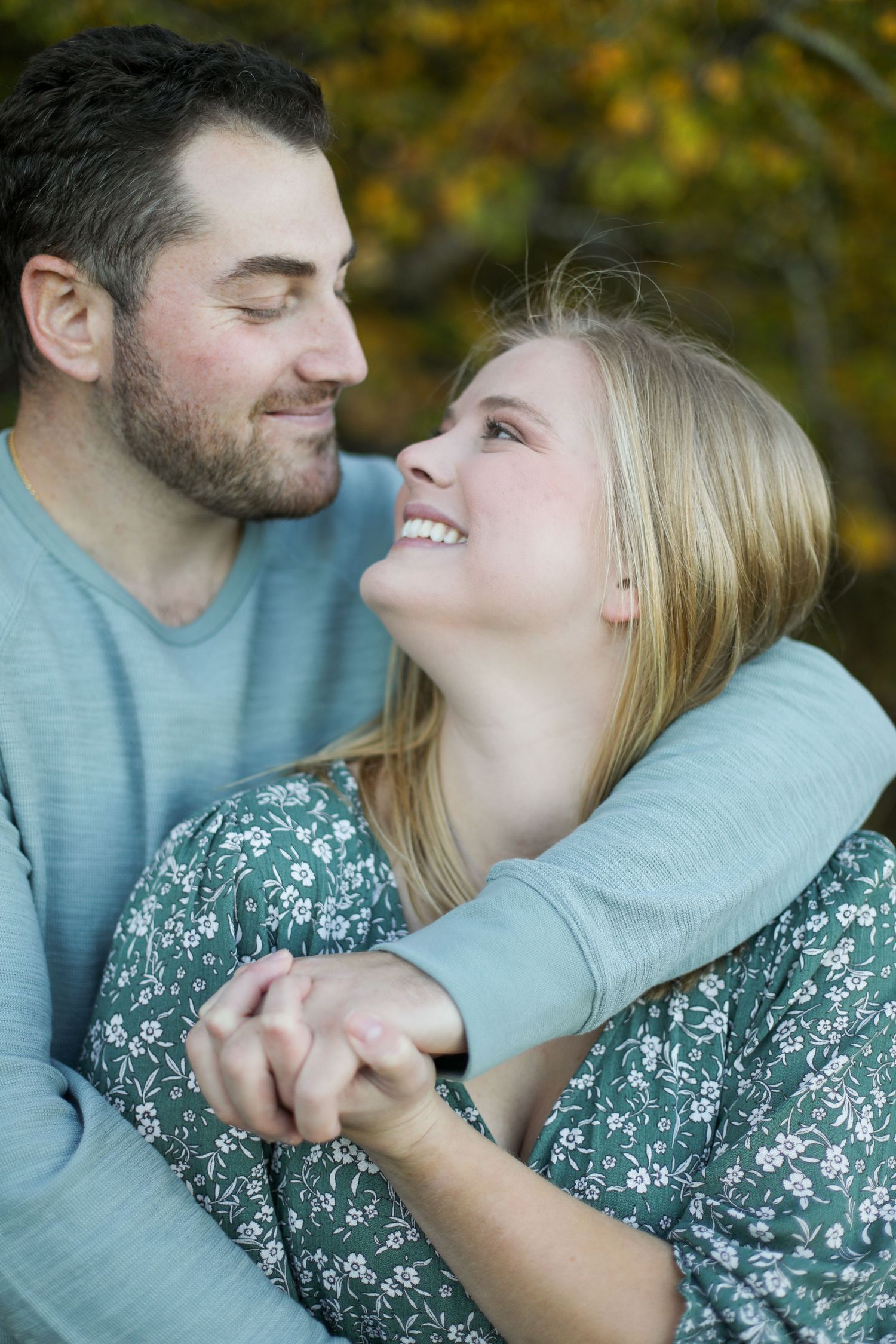 A couple sharing a joyful embrace outdoors during autumn.