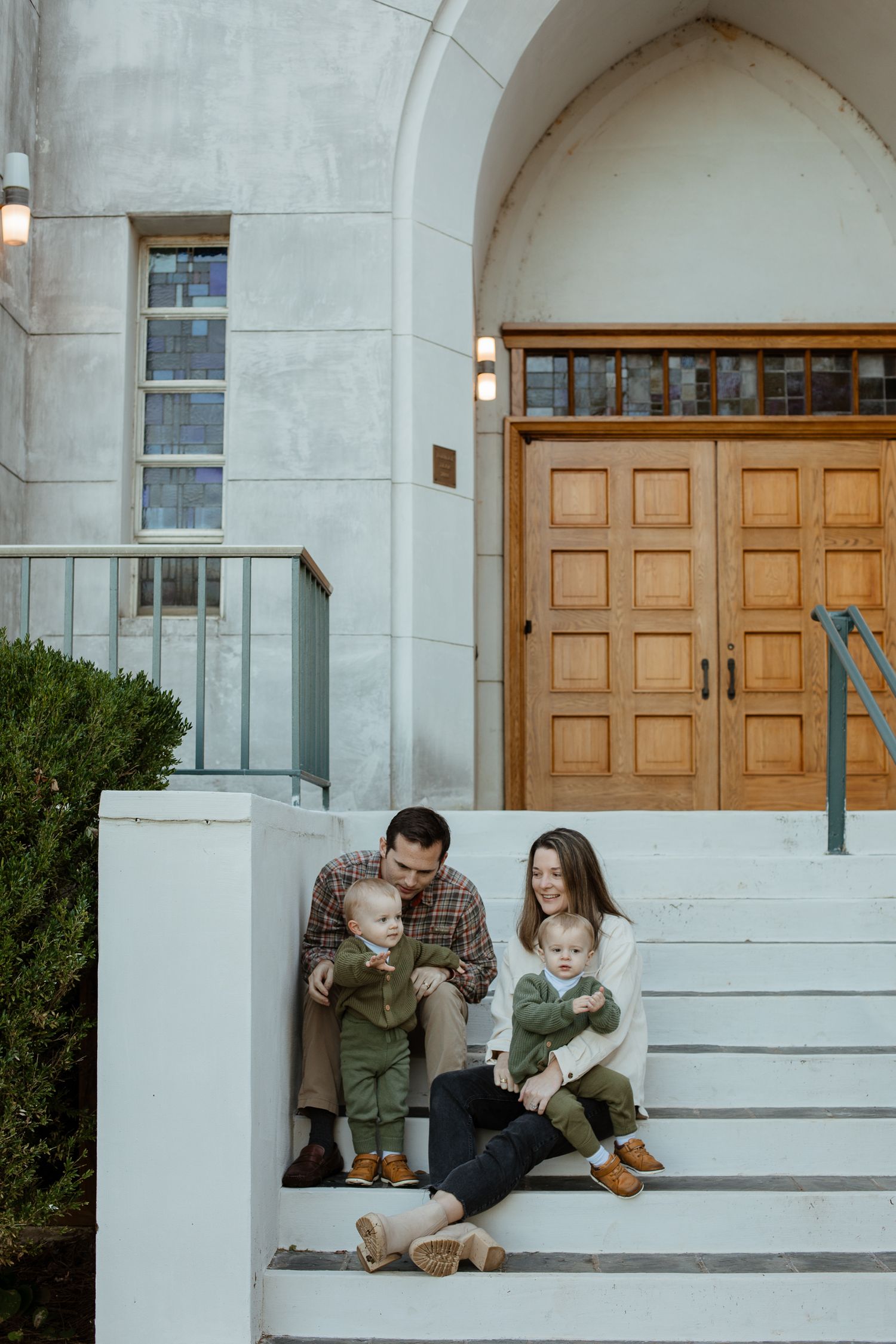 White stone building entrance with wooden doors and architectural details.