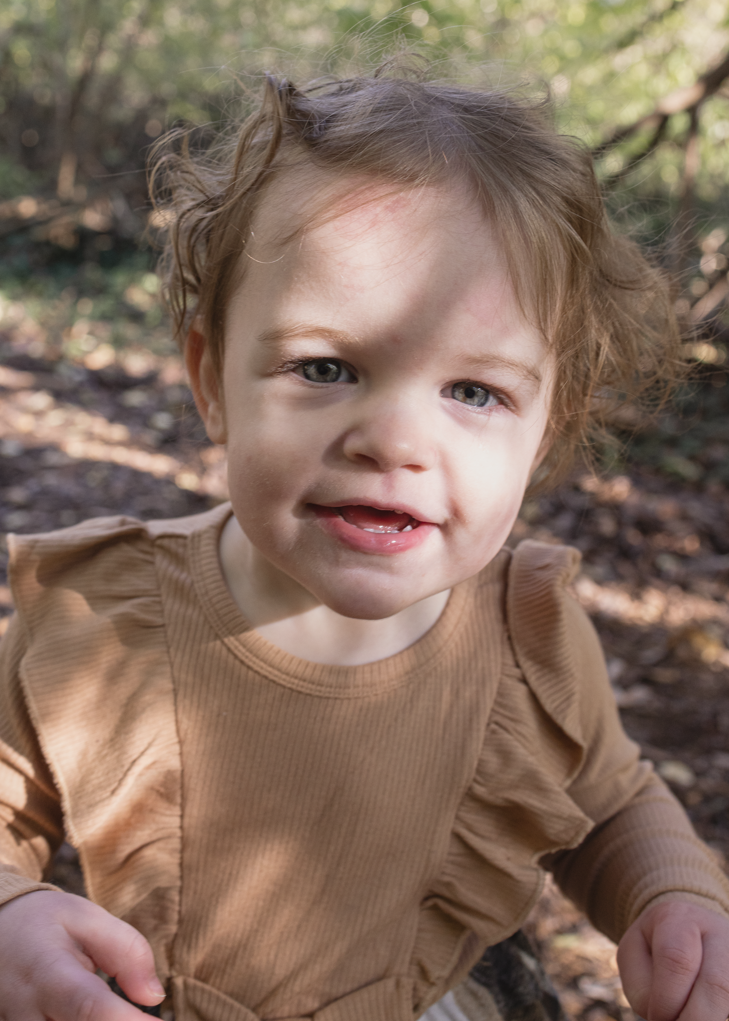 A series of four photos showing a child in a brown ruffled shirt playing outdoors in natural lighting.