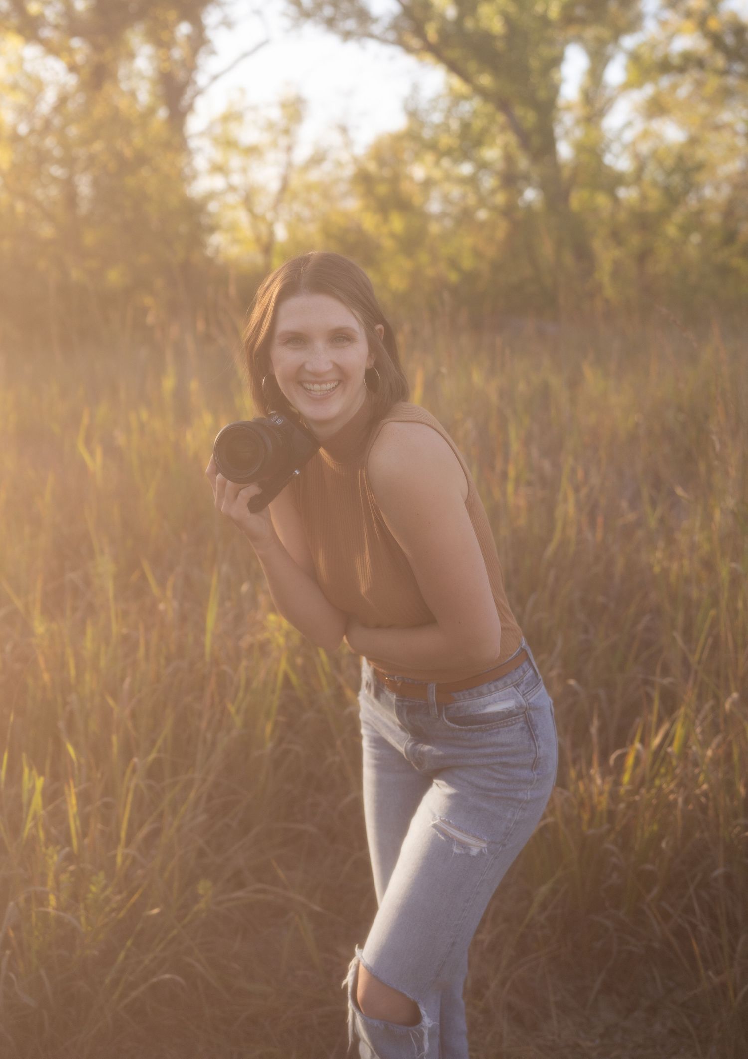 A candid photoshoot in a golden field during sunset featuring casual denim attire.