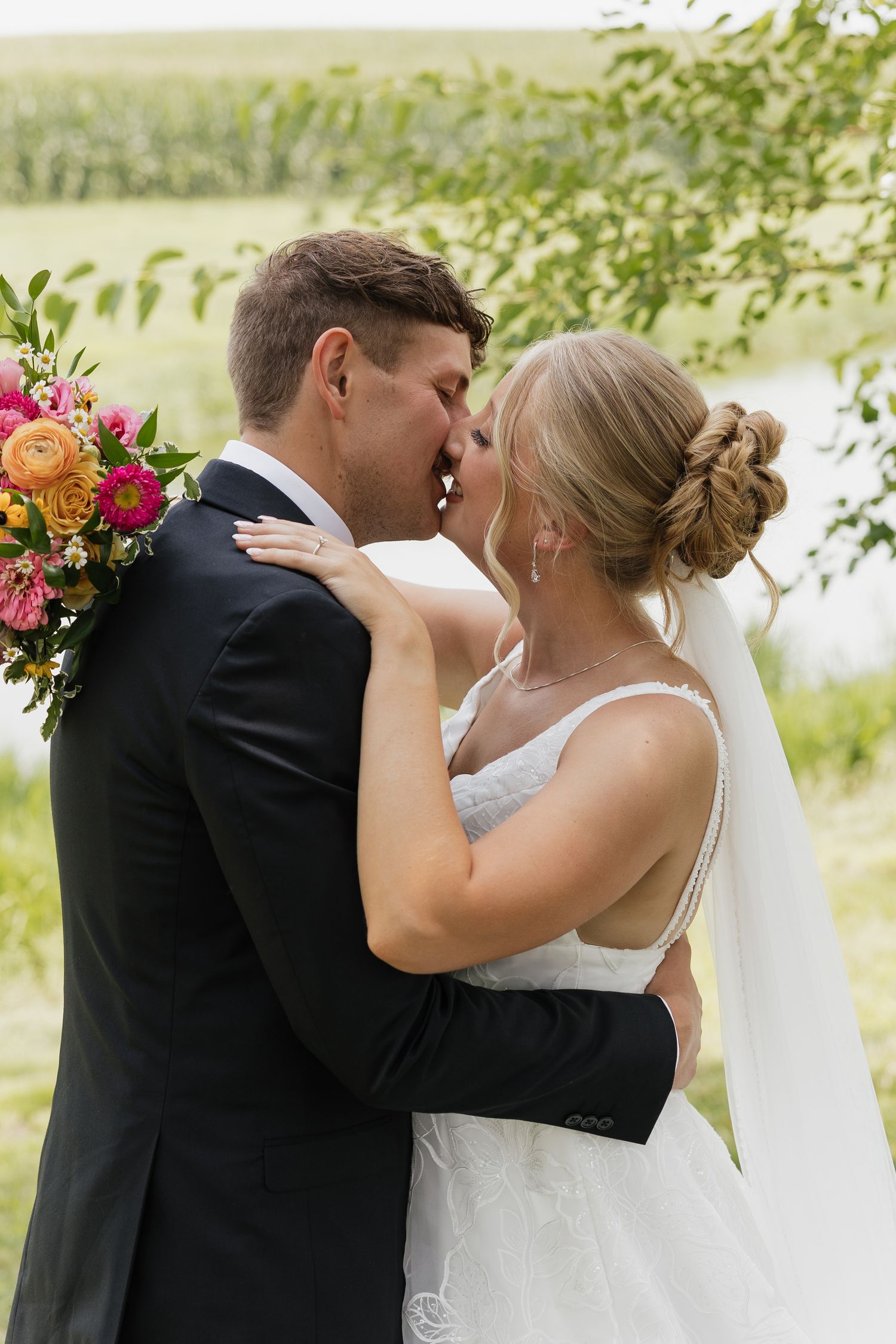 A romantic wedding photo sequence shows a couple's first kiss as newlyweds by a lake with floral decorations.