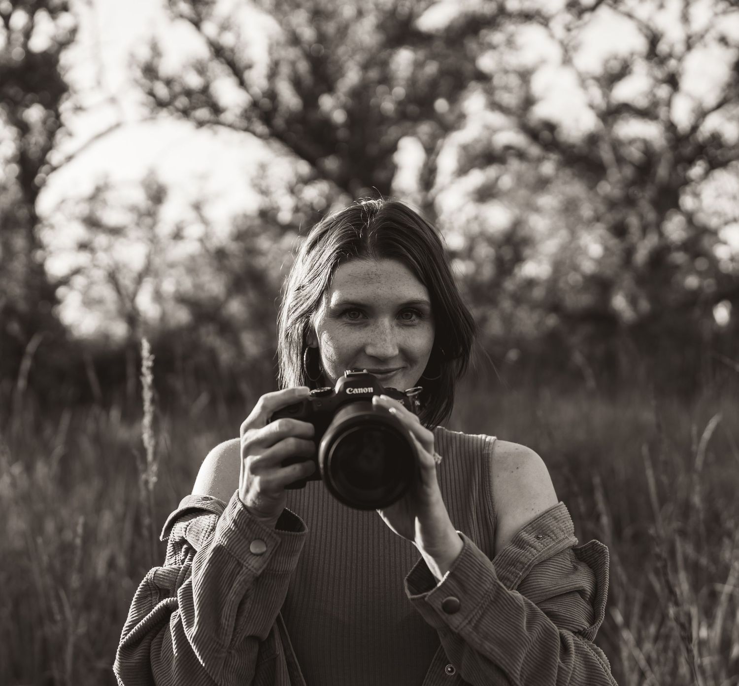 Black and white series of photographer holding camera in outdoor setting.