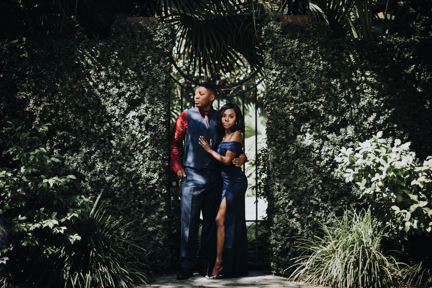 couple in formal attire posing surrounded by greenery in downtoan savannah georgia