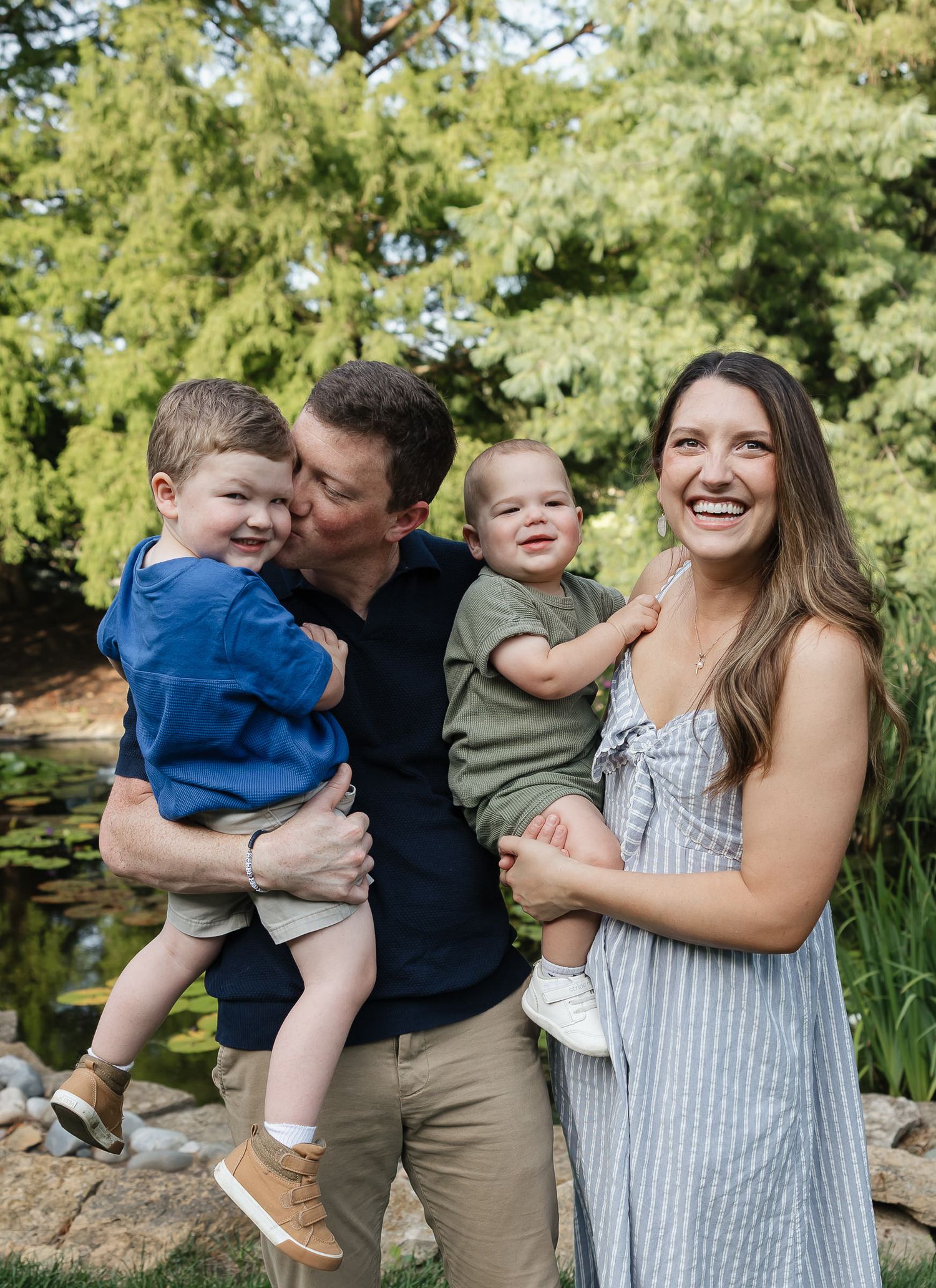 photographer overland park ks husband and wife holding and snuggling their toddler boys at antioch park