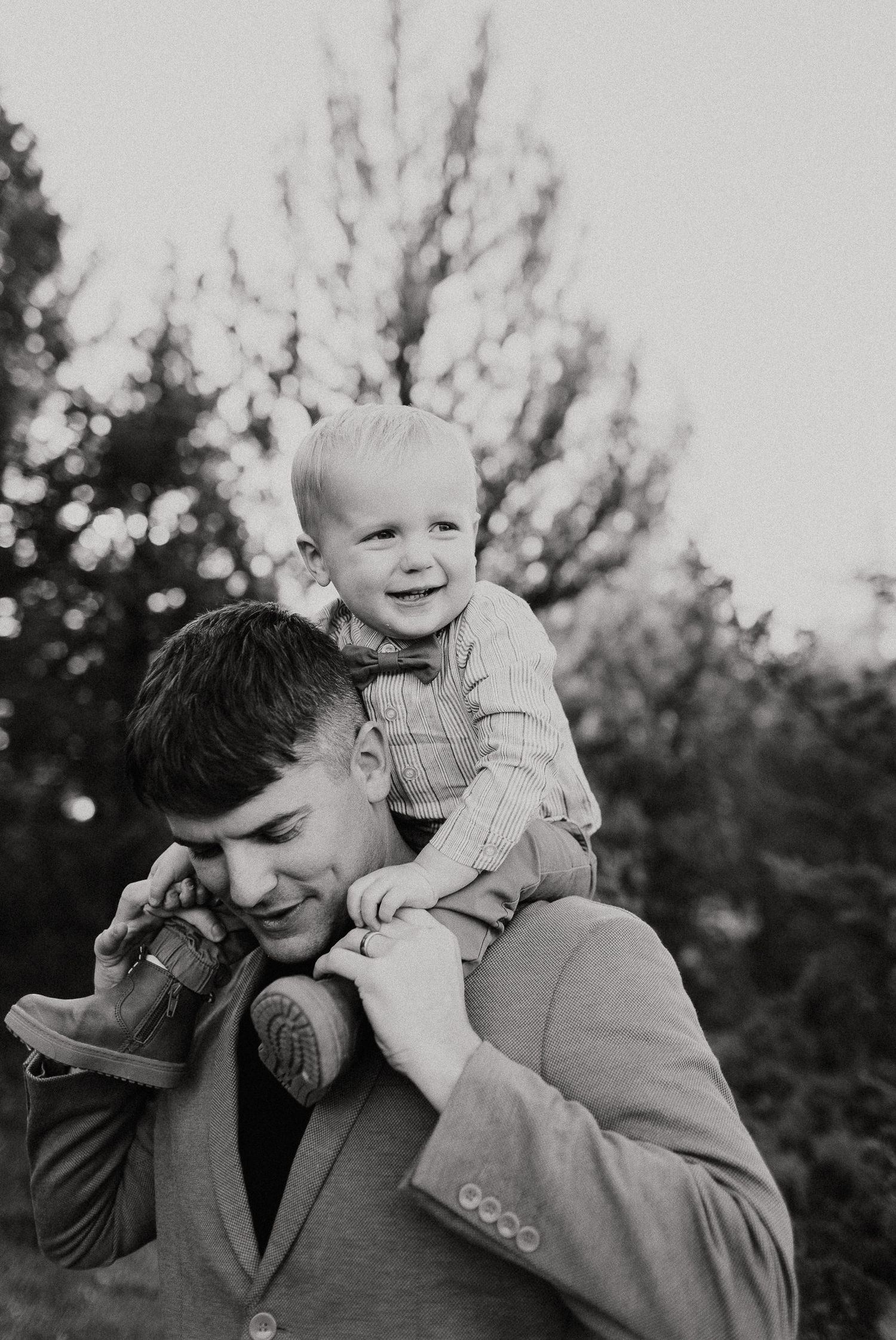 dad walking with his toddler on his shoulders smiling Photographer overland park ks