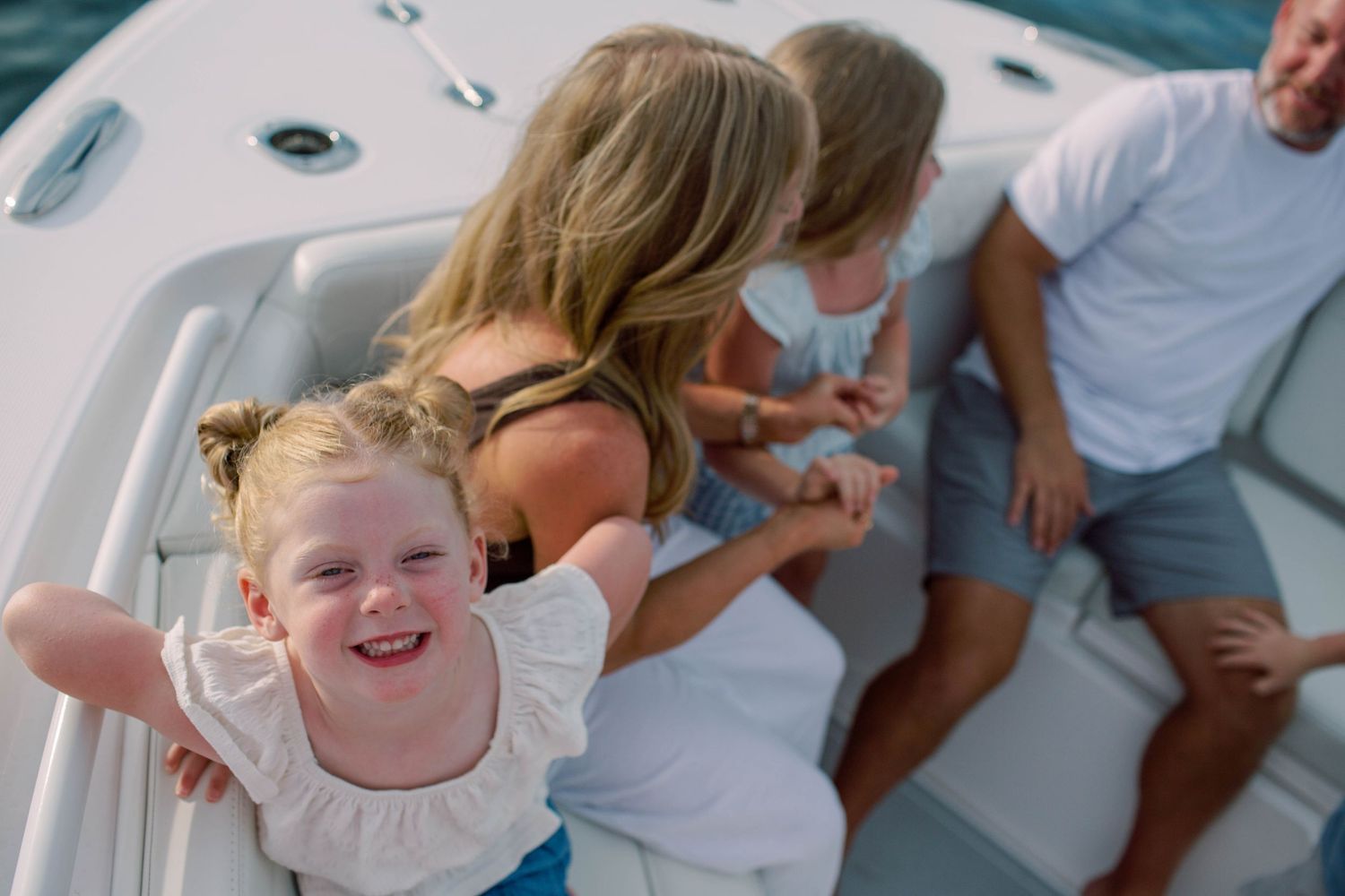 Joyful young girl on a white boat with her family enjoying a day on the water.