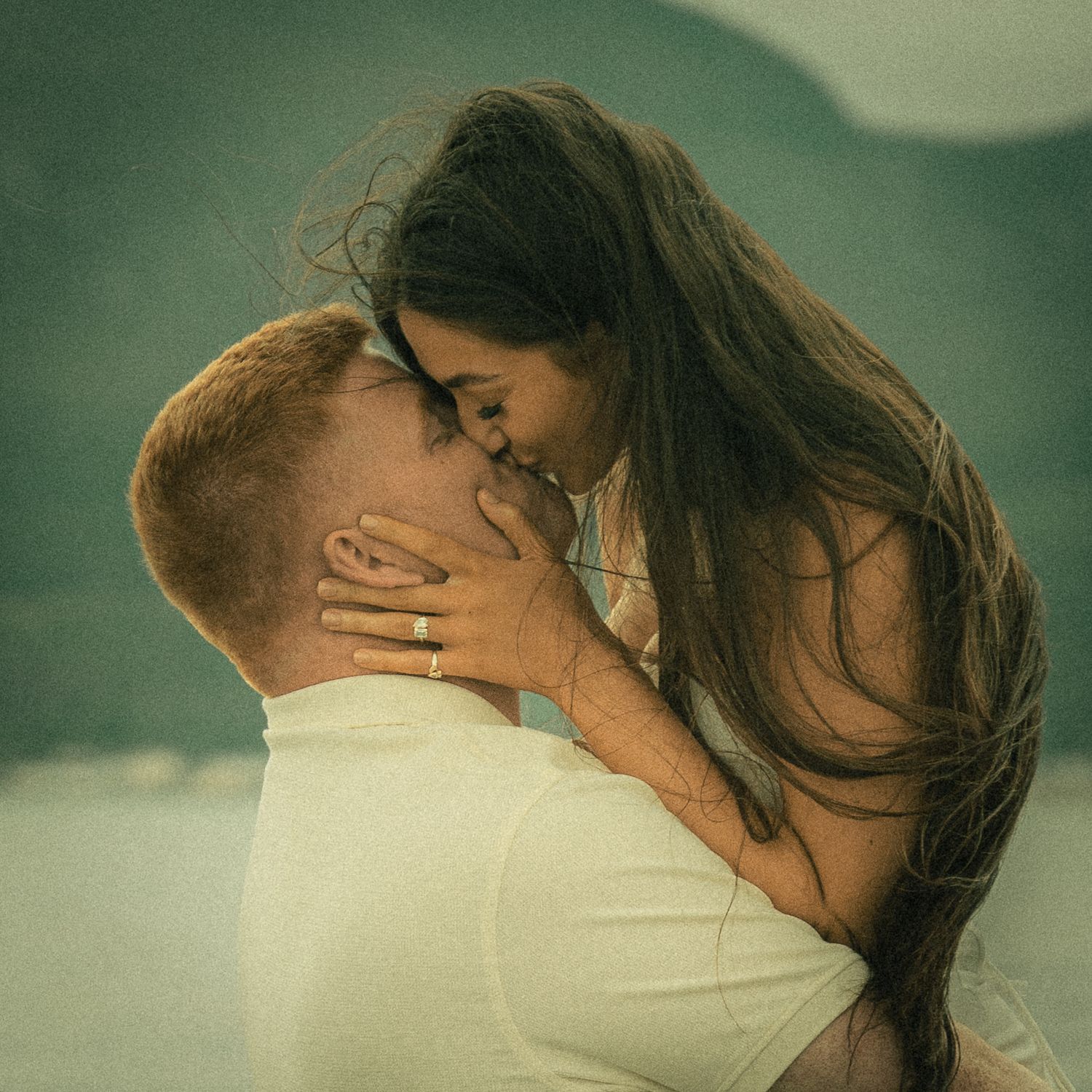 Film-inspired close-up of a newlywed couple sharing a kiss, captured mid-air in a joyful and romantic moment.
