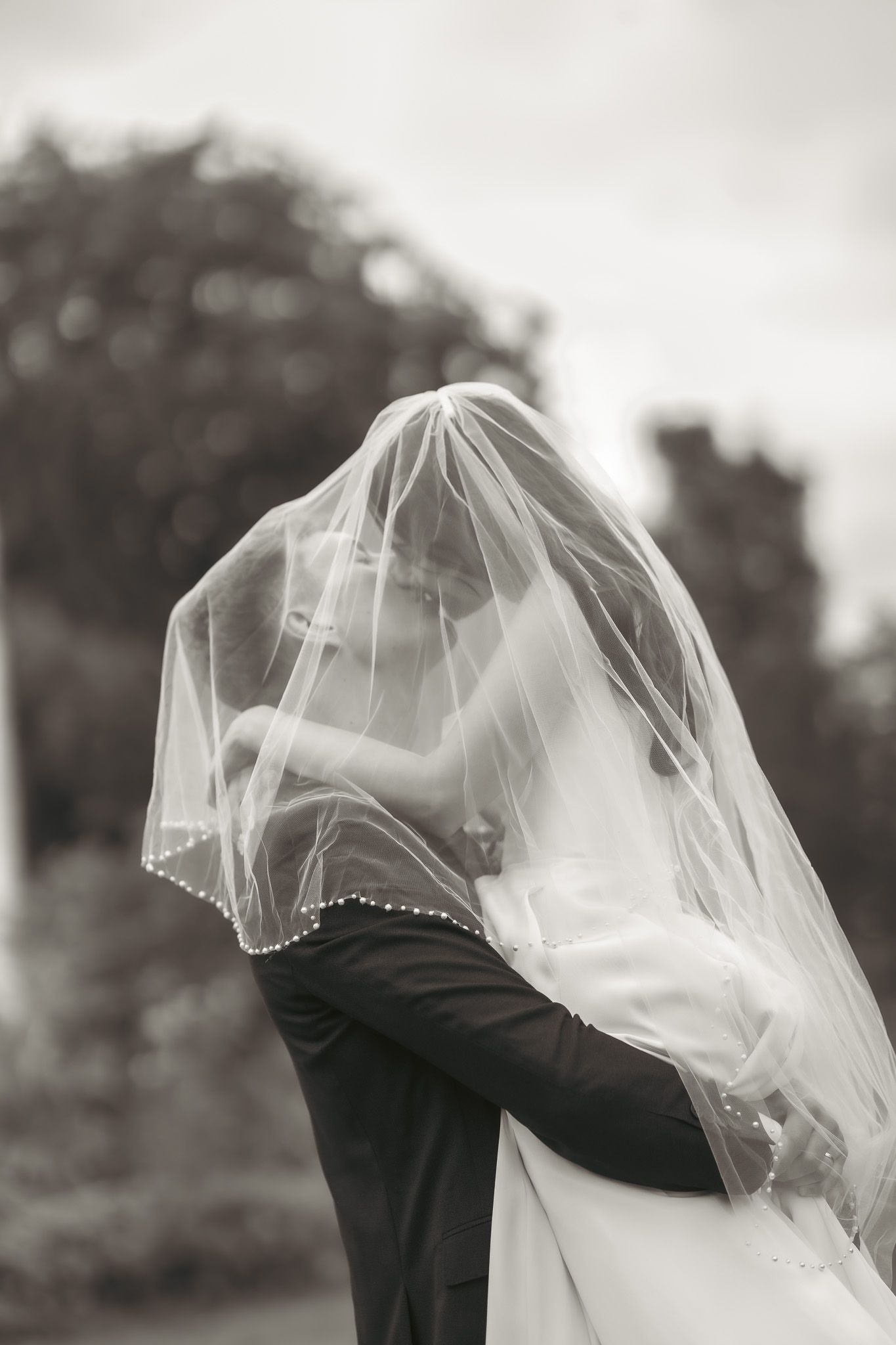 Bride and groom lift and embrace.