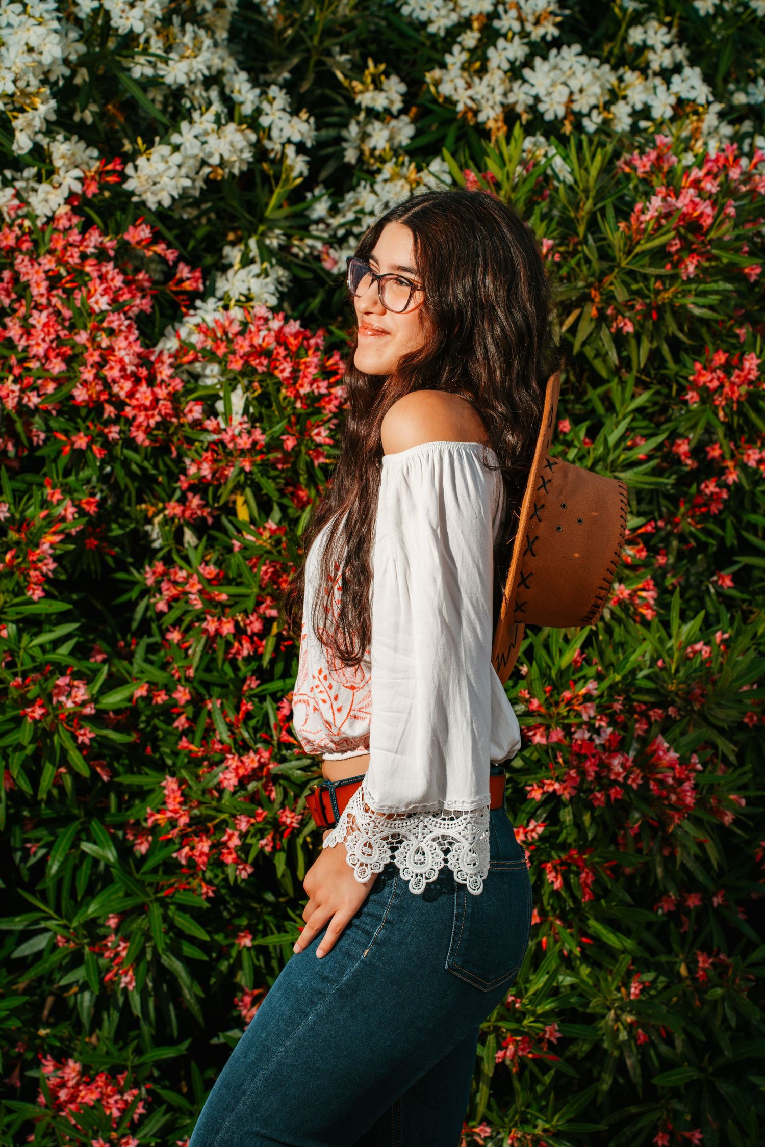 Retrato de una mujer junto a un jardín de flores rojas