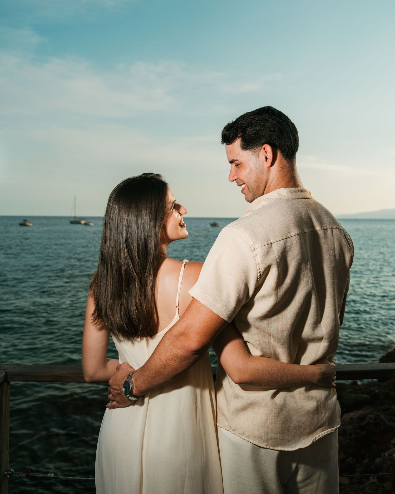 Pareja abrazada dentro del agua durante una sesión fotográfica junto al mar