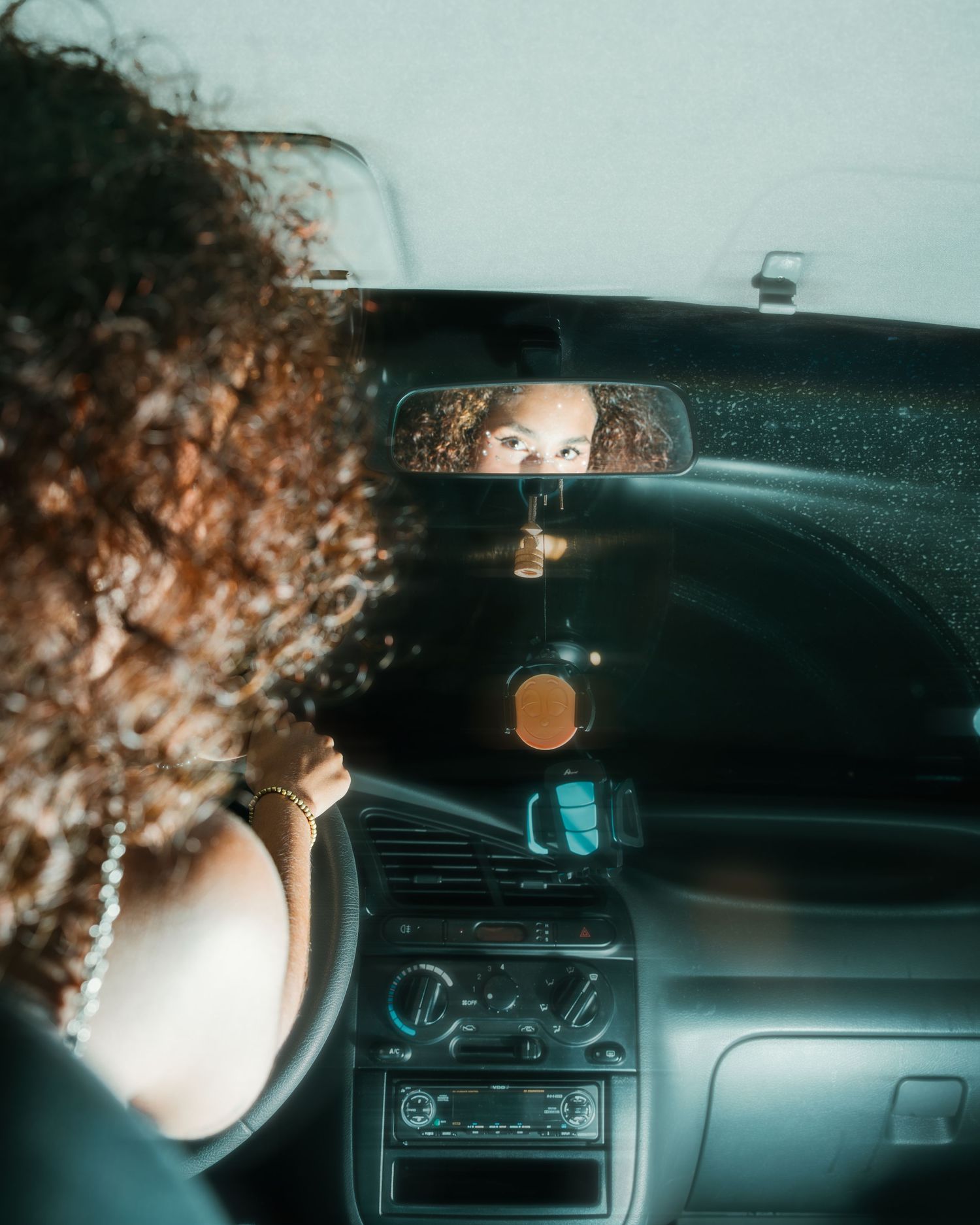 Retrato de una mujer al volante de un coche durante una sesión fotográfica urbana