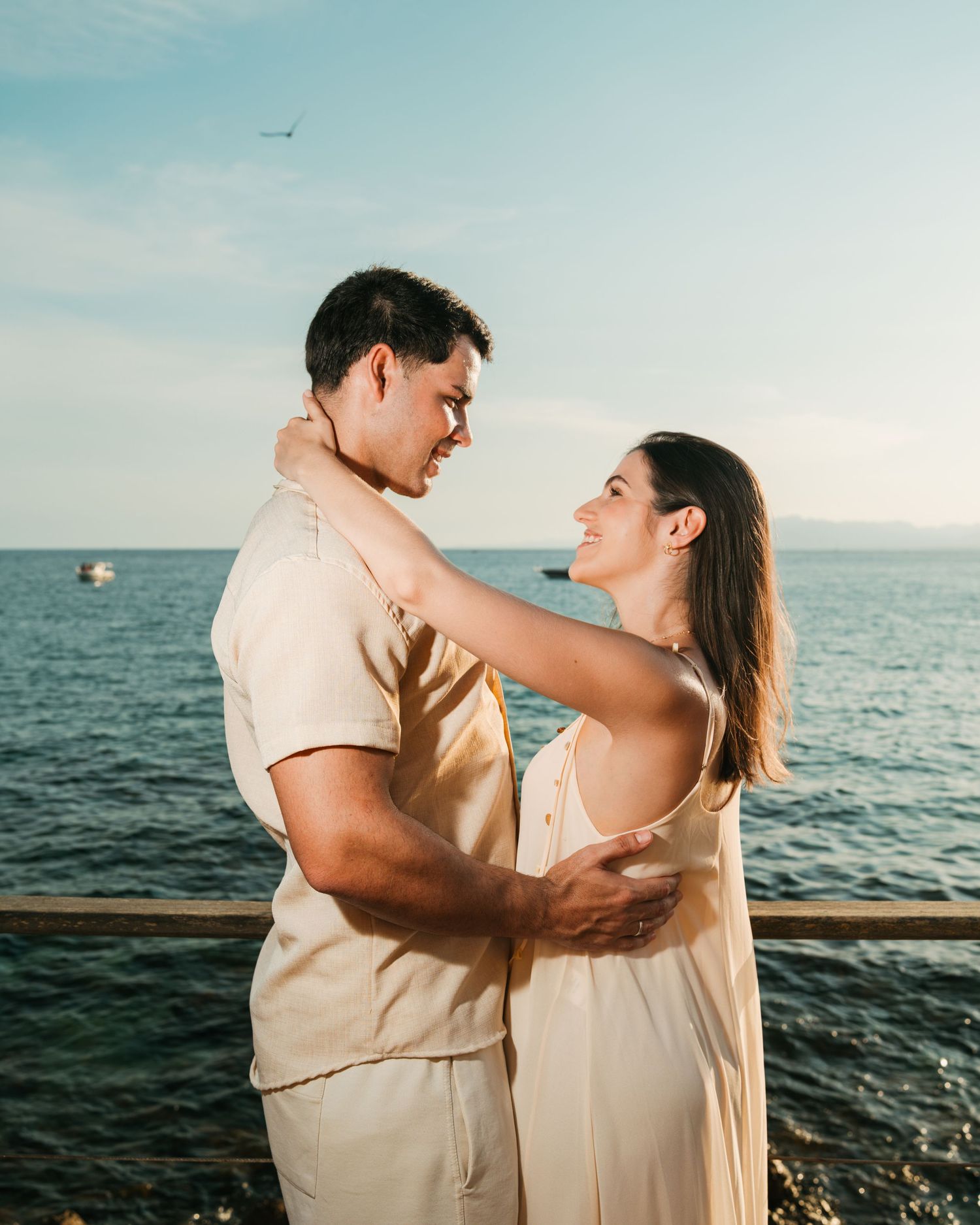 Pareja abrazada dentro del agua durante una sesión fotográfica junto al mar