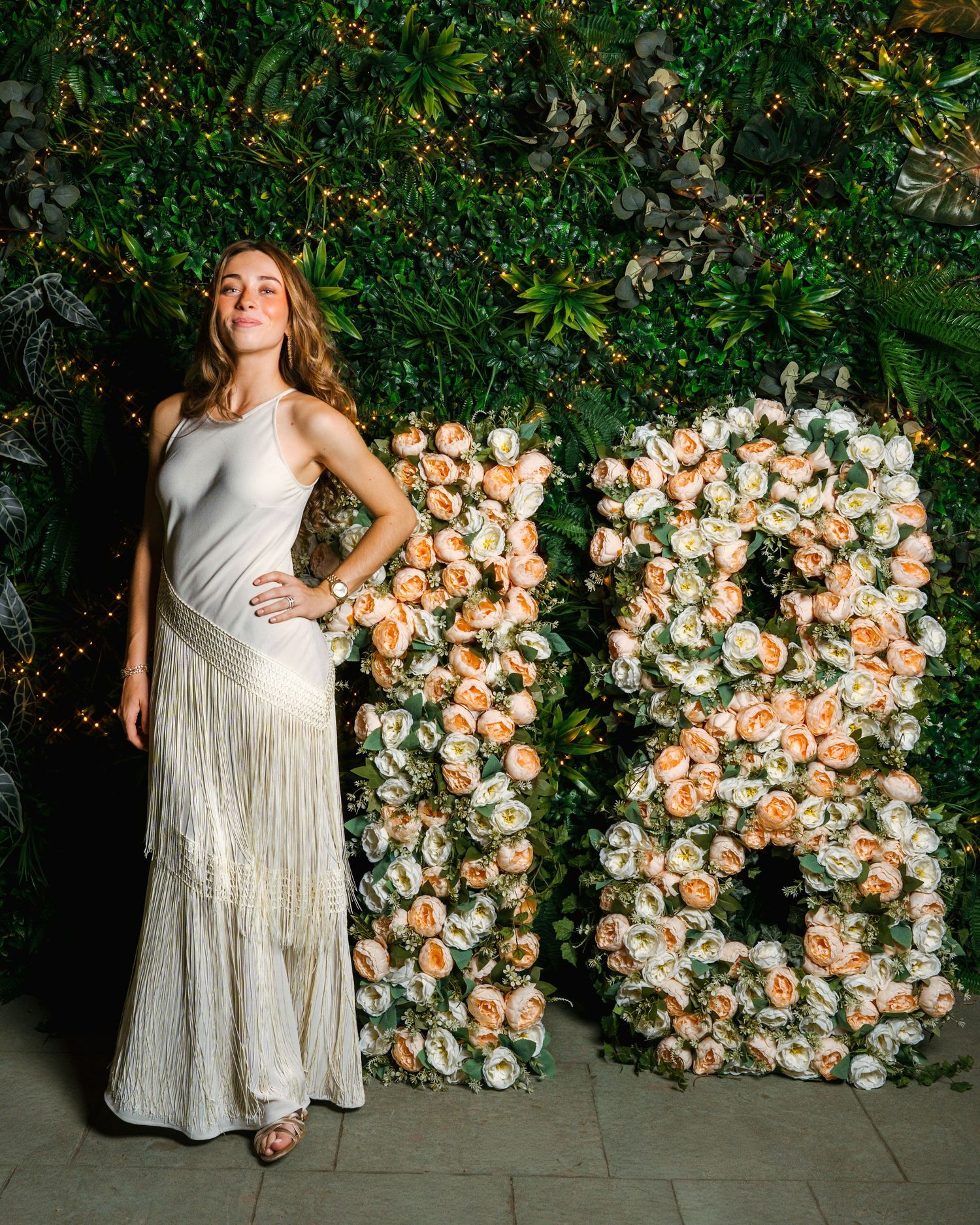 Retrato de una joven con vestido elegante junto a una decoración floral