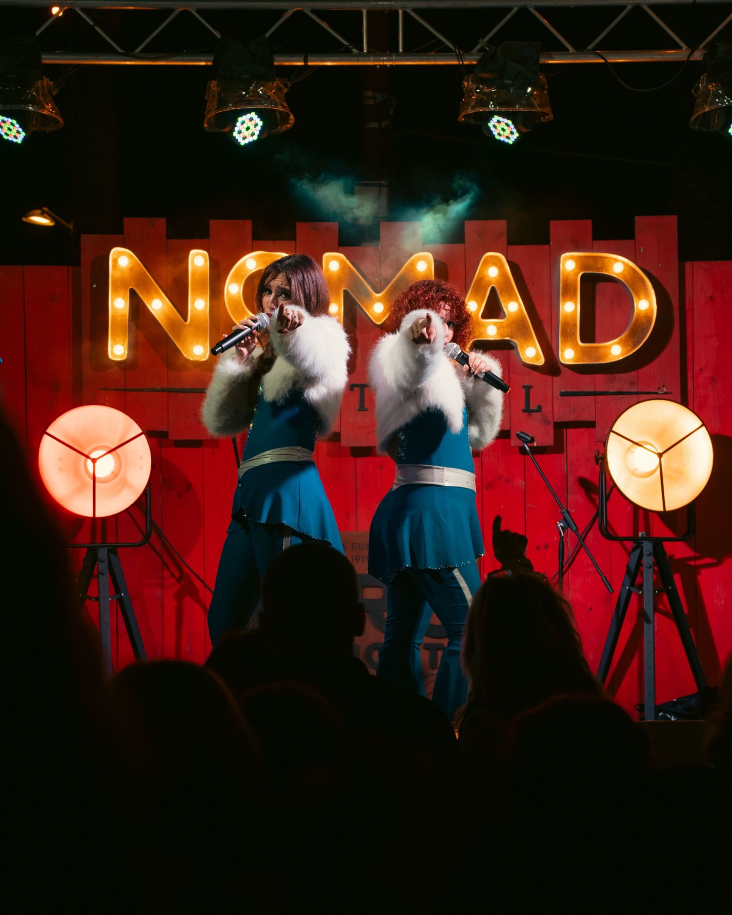 Artistas actuando en un escenario durante un evento musical nocturno