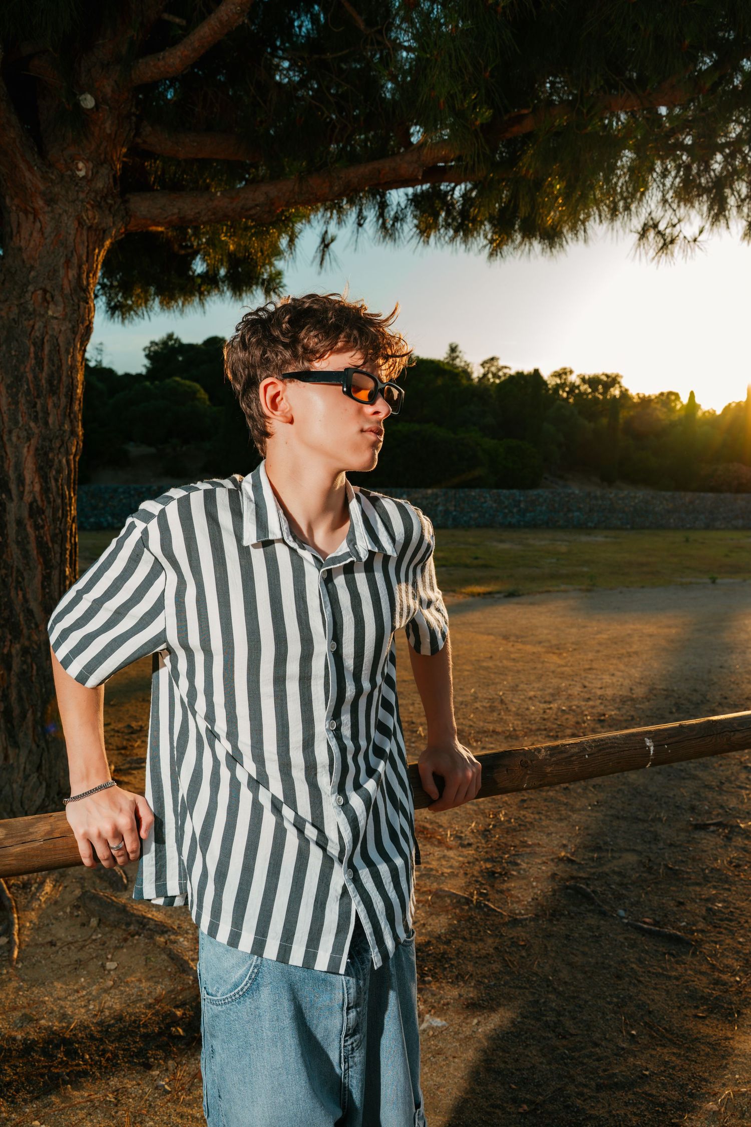 Retrato de un joven con camisa de rayas en un entorno natural