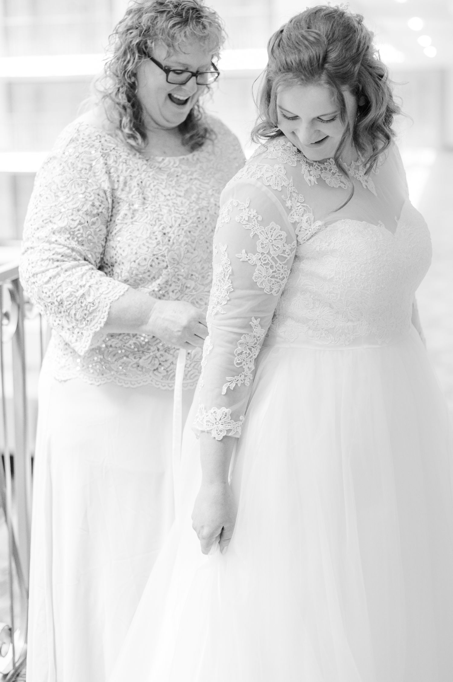 Bride zips wedding dress ahead of Catholic wedding at Most Precious Blood Parish in Tulsa, OK.