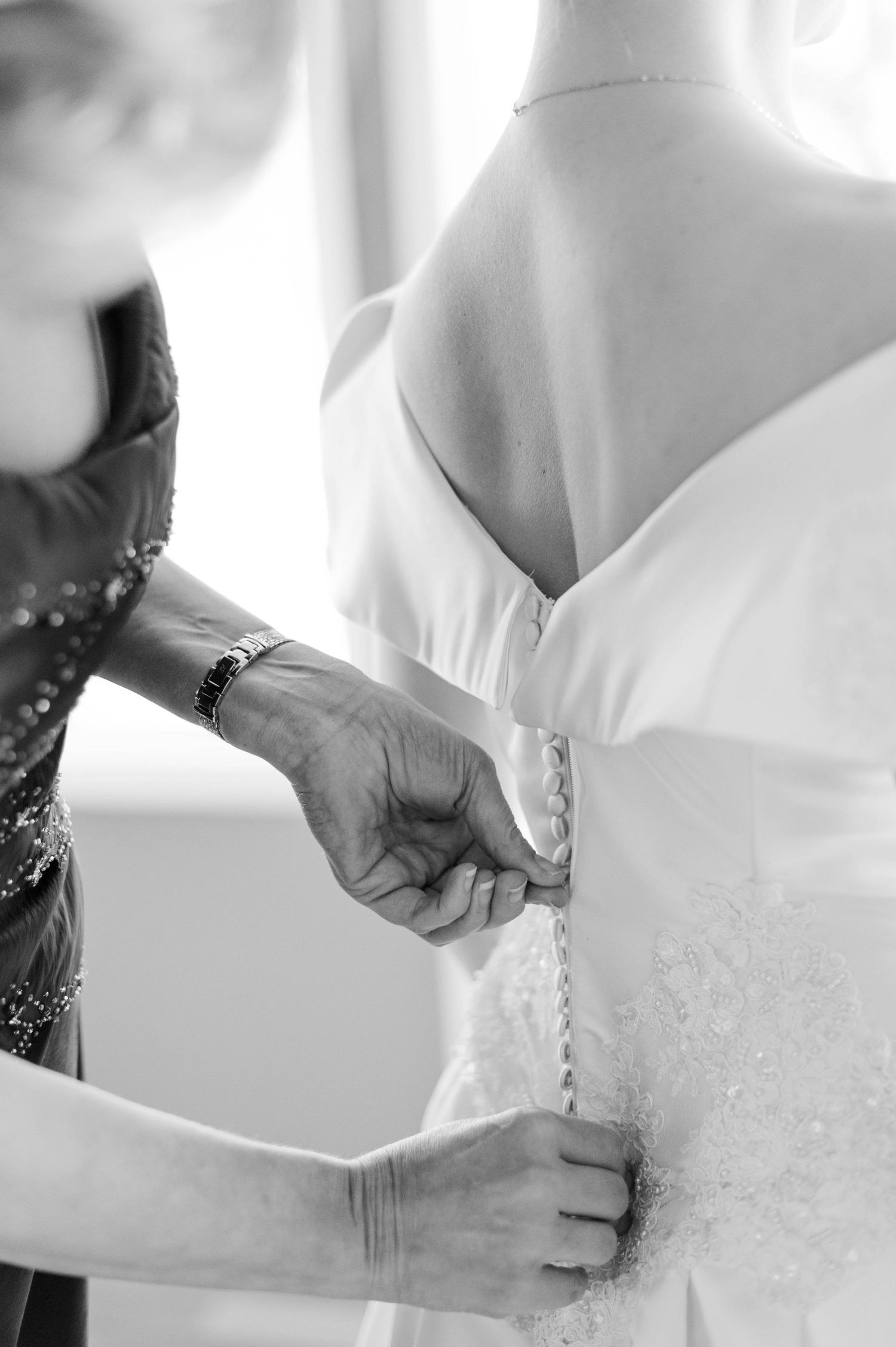 Mother of the bride zips wedding gown for a Catholic wedding at Holy Family Cathedral in Tulsa, OK.