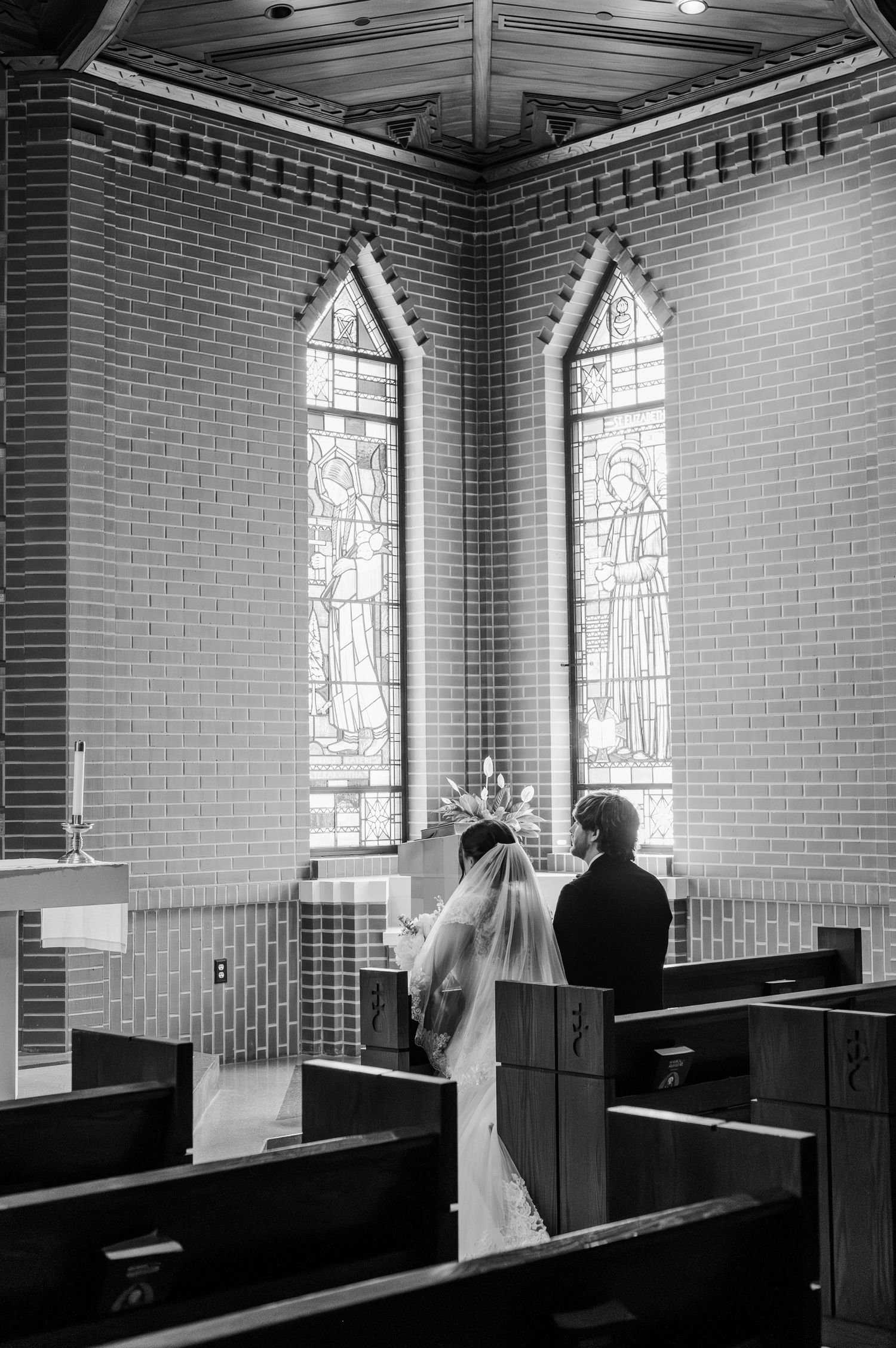 Bride and groom pray in adoration chapel after their catholic wedding at Parish of Christ the King in Tulsa, OK.