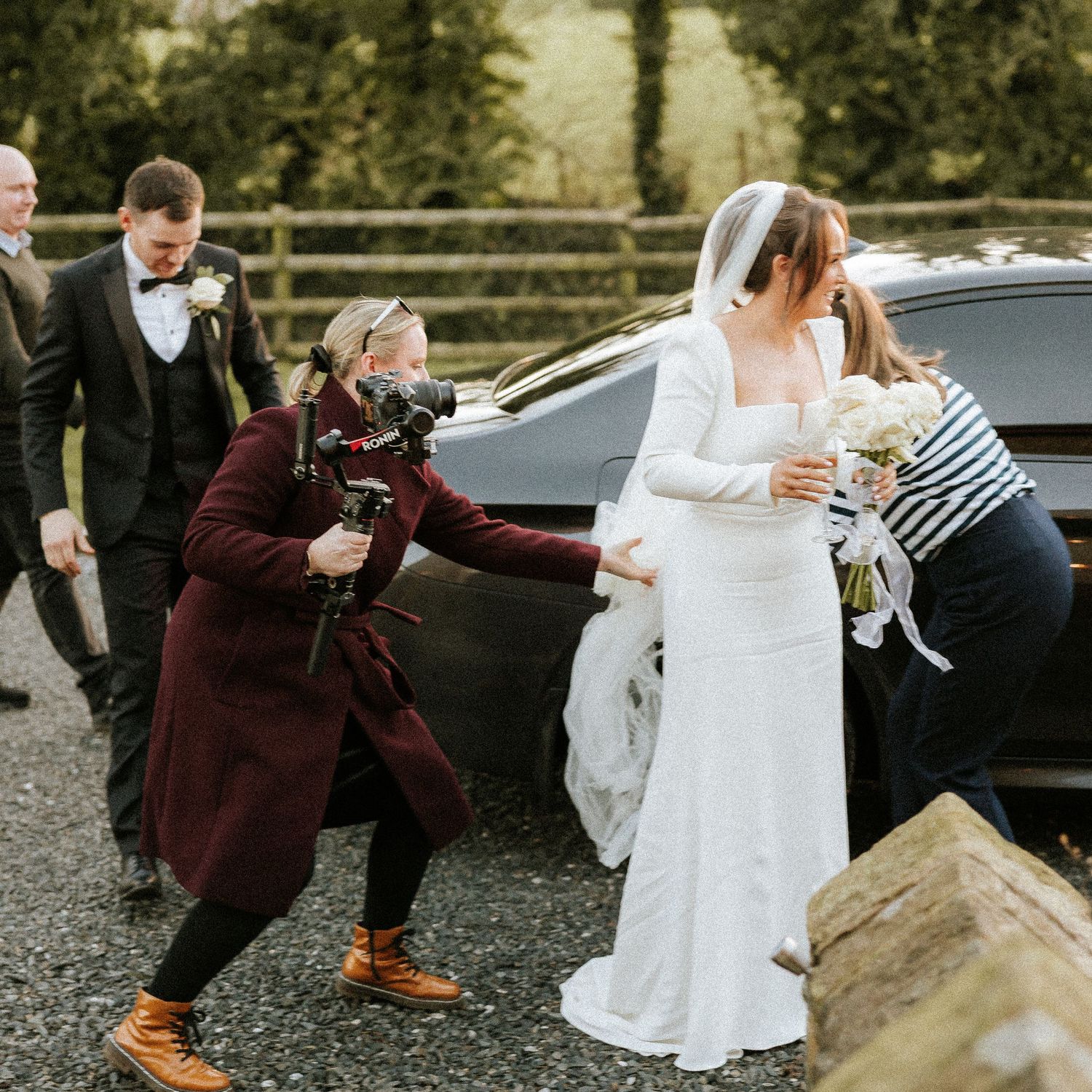A sequence of playful wedding photos showing the bride and groom dancing and twirling in burgundy and white attire.