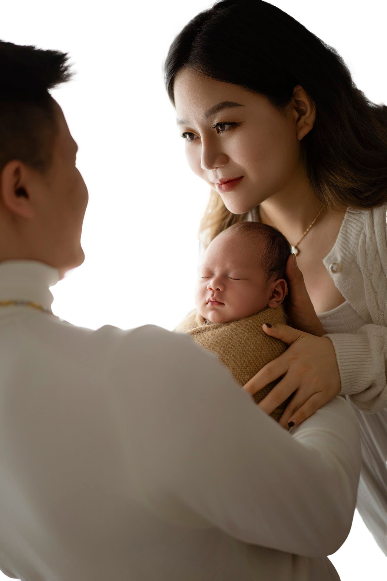 Intimate family portrait in soft natural lighting with gentle expressions.