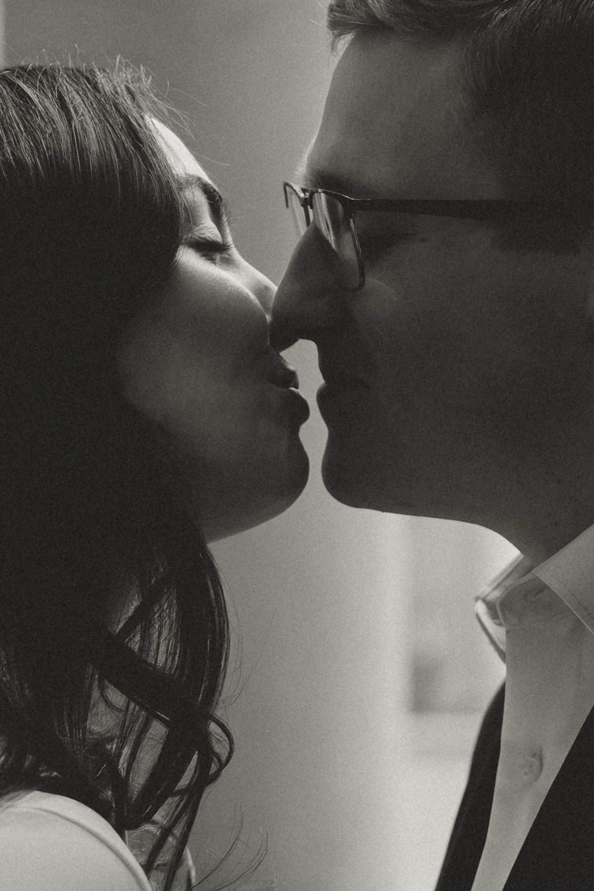 A romantic black and white photo series showing silhouettes of a couple about to kiss in dramatic lighting.