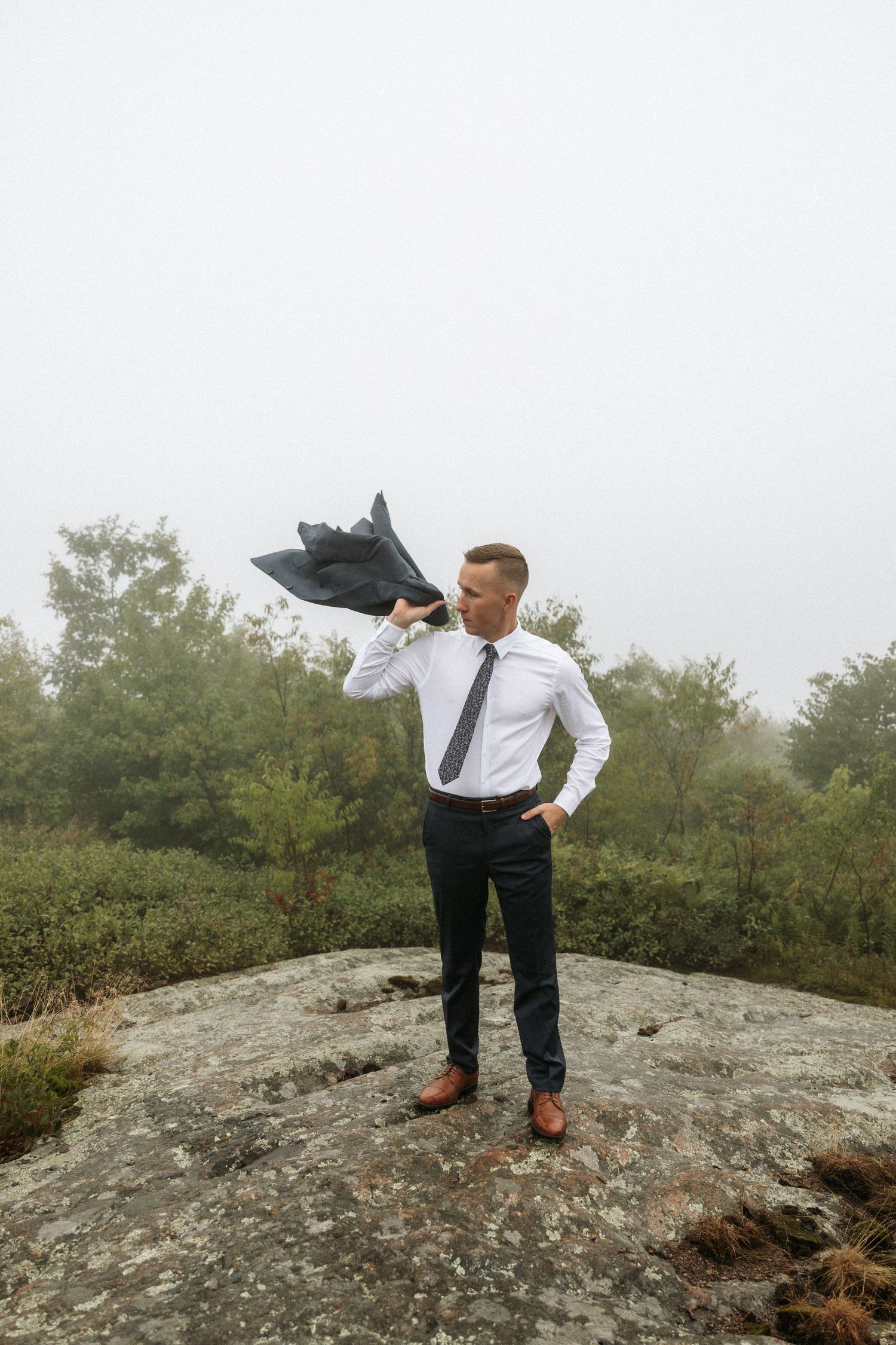 groom throwing jacket over shoulder
